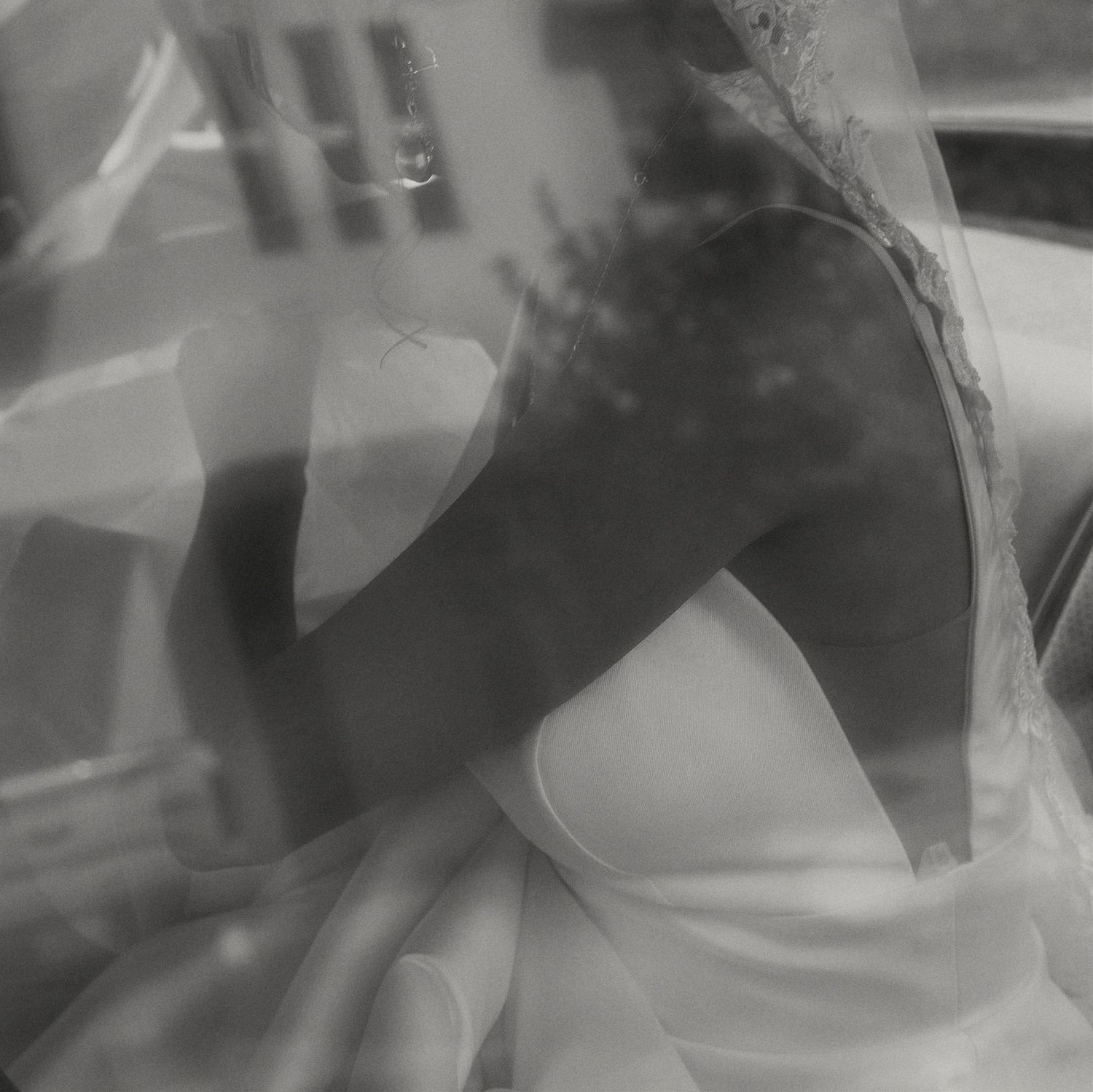 Ethereal black and white photo showing close-up details of a wedding dress.