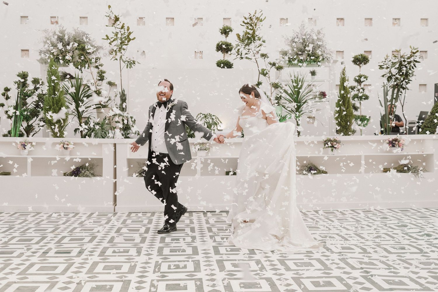 Elegant wedding ceremony setup with stone pathway and white walls in an outdoor courtyard.