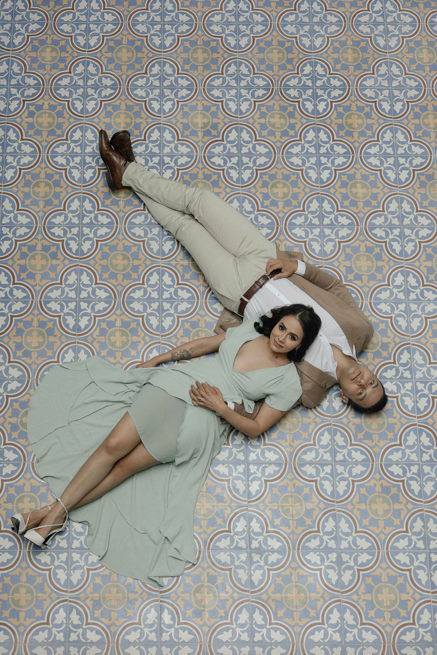 A sequence of four photos showing someone lying down on a floor with decorative patterned tiles in various poses.