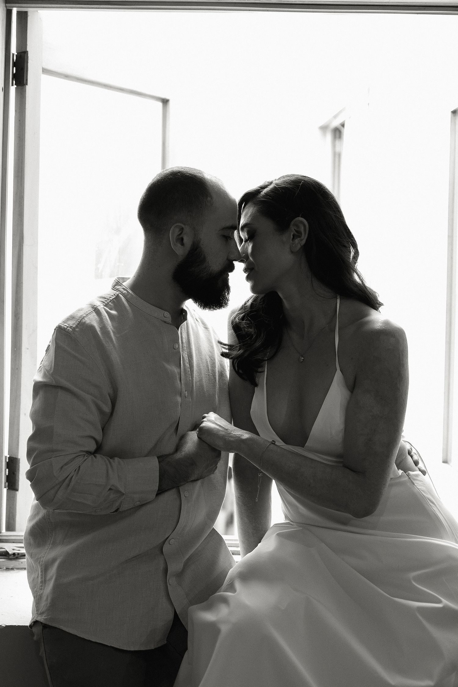 A sequence of romantic black and white photos showing a couple in wedding attire sharing intimate moments.