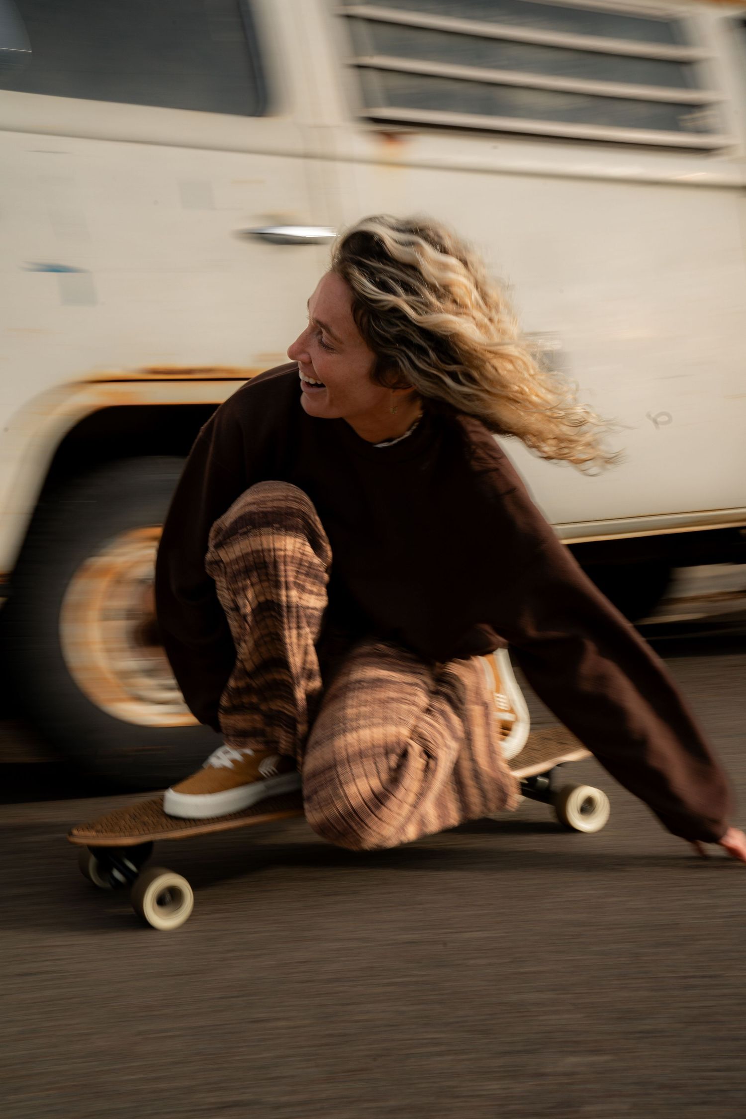 Girl skating in Volcom apparel, showcasing bold style and dynamic movement on a sunny day near a white van