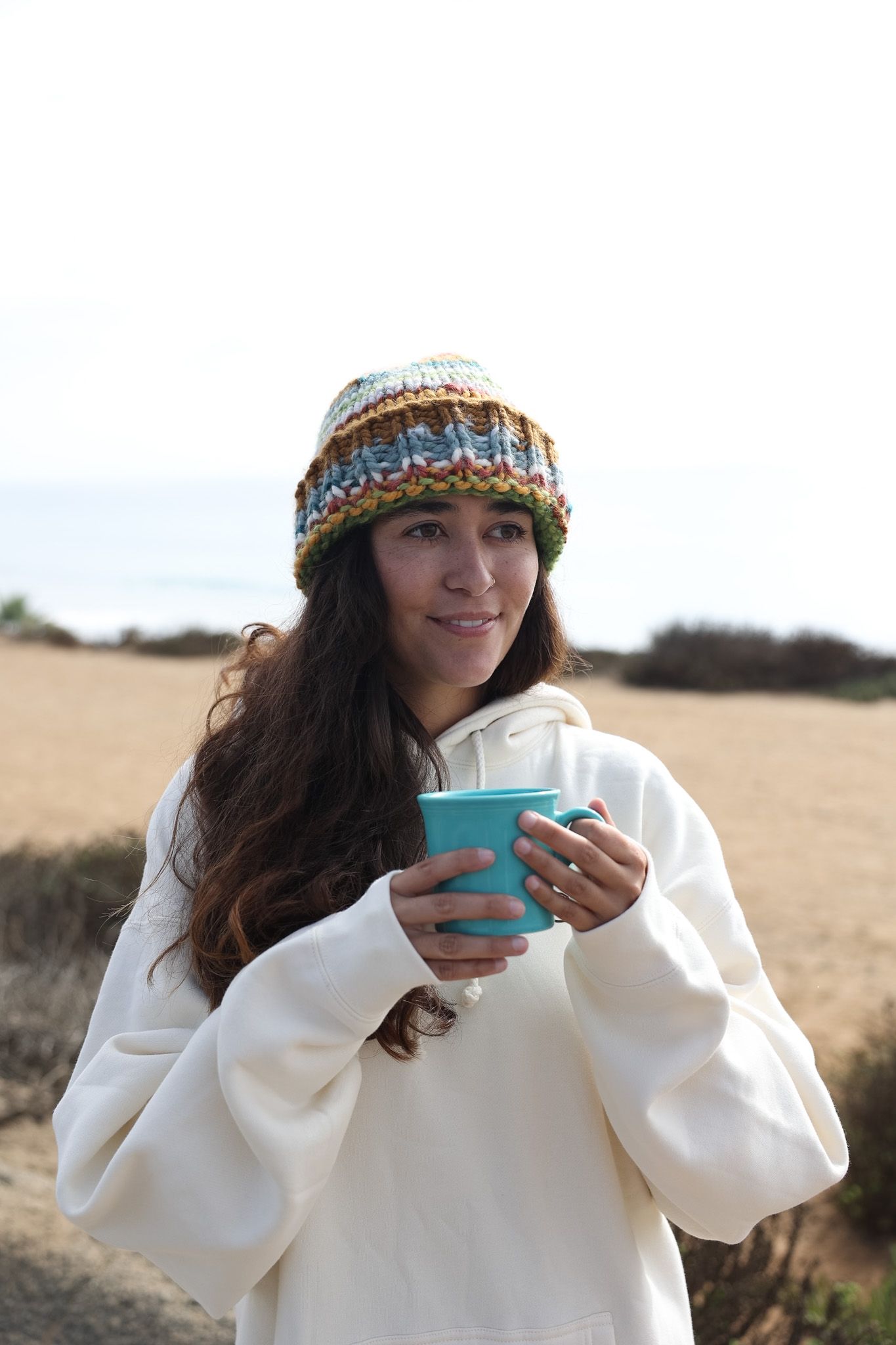 Girl wearing a white Sunbum Jacket, enjoying a partly sunny day while standing with skateboarding  promoting Sunbum sunscreen.