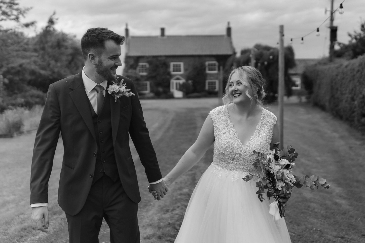 A romantic outdoor wedding photoshoot with couples walking and embracing along a country path.