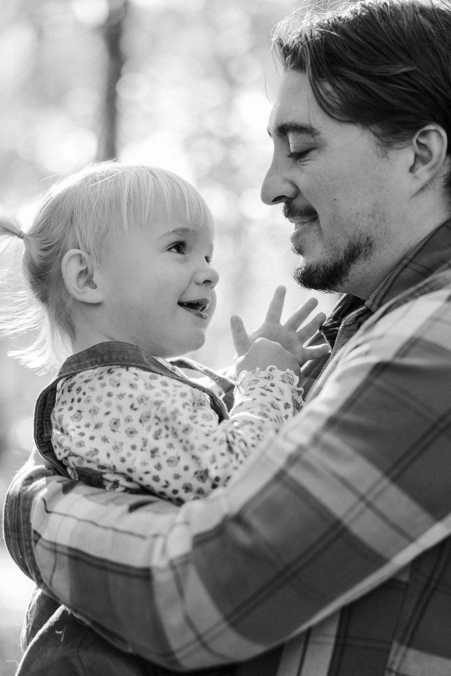 A series of black and white photos showing tender moments between a parent and child in a gentle embrace.