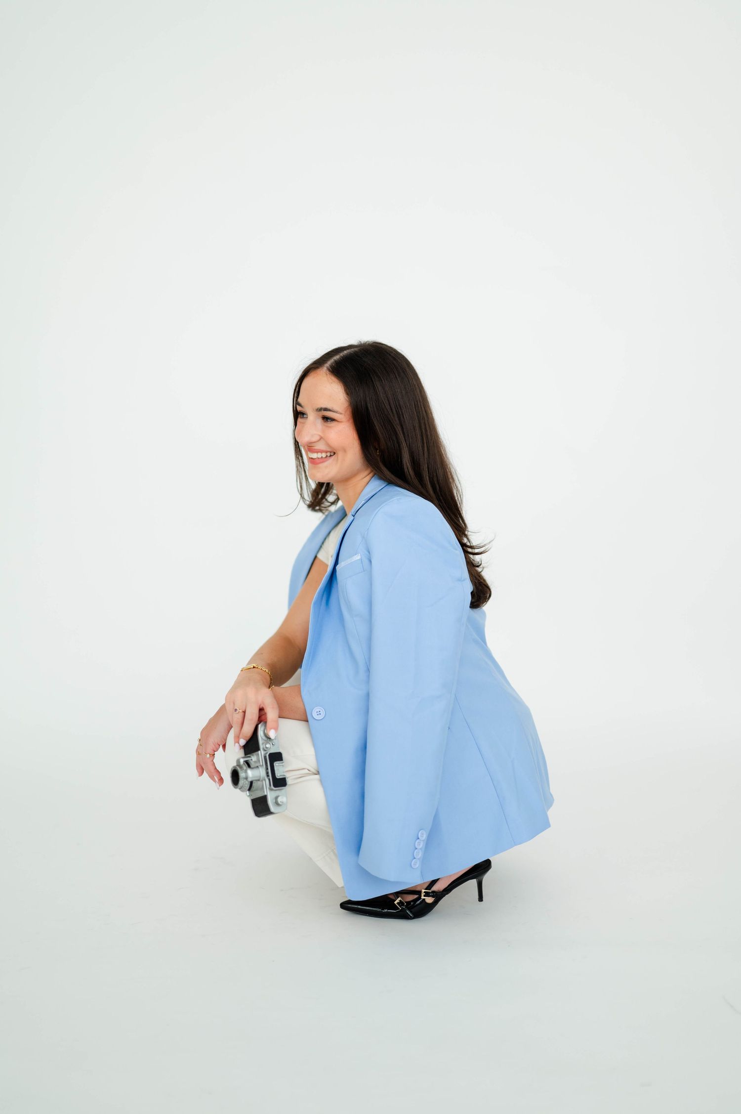 Person in light blue shirt crouching and sitting in different poses against white background.