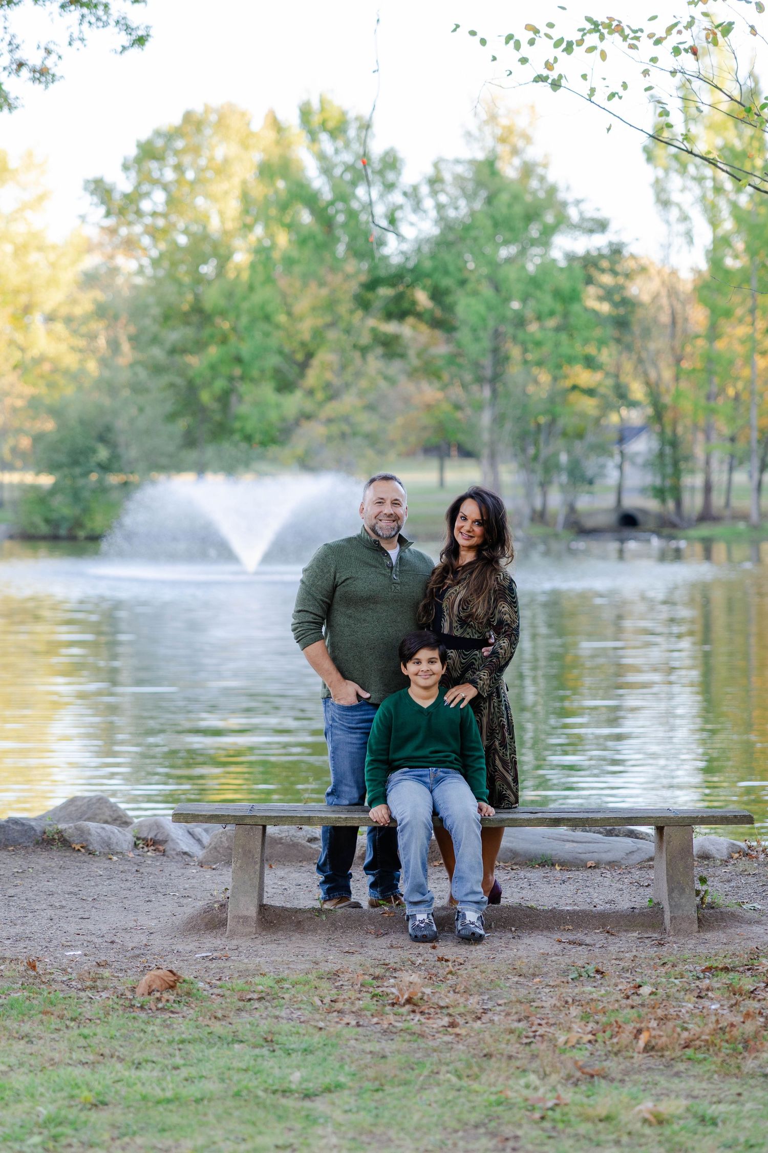 Three casual outdoor family photos by a lake with a fountain showing a relaxed autumn scene in nature.