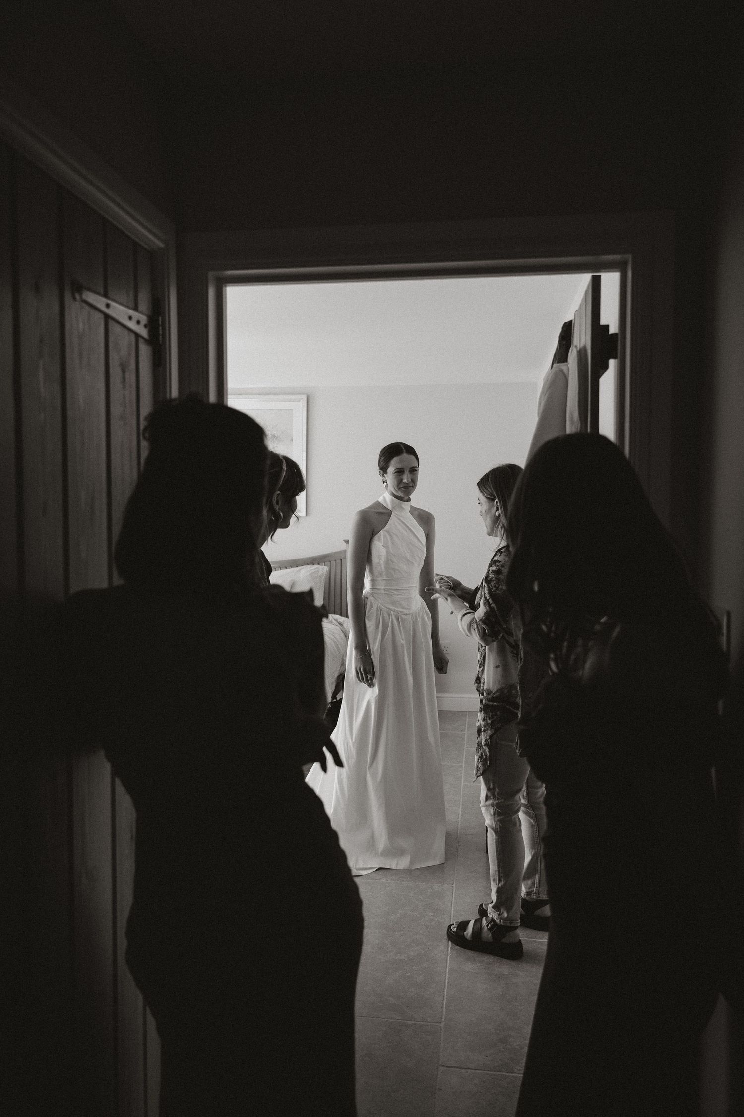 A series of black and white photos showing silhouettes in a dimly lit hallway with a bright doorway at the end.