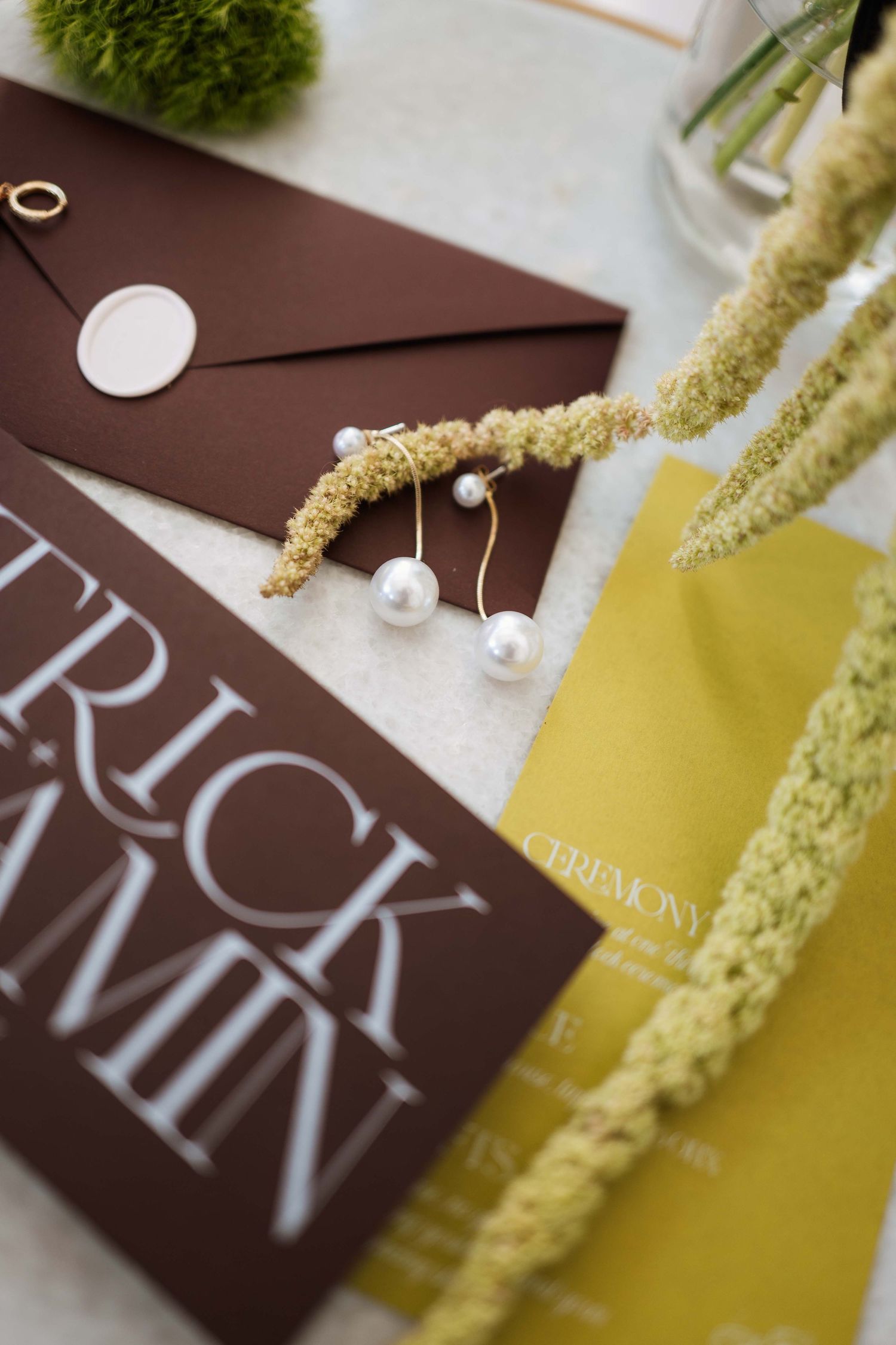 Brown and yellow wedding invitation cards with elegant typography and dried floral accents create a modern design layout.