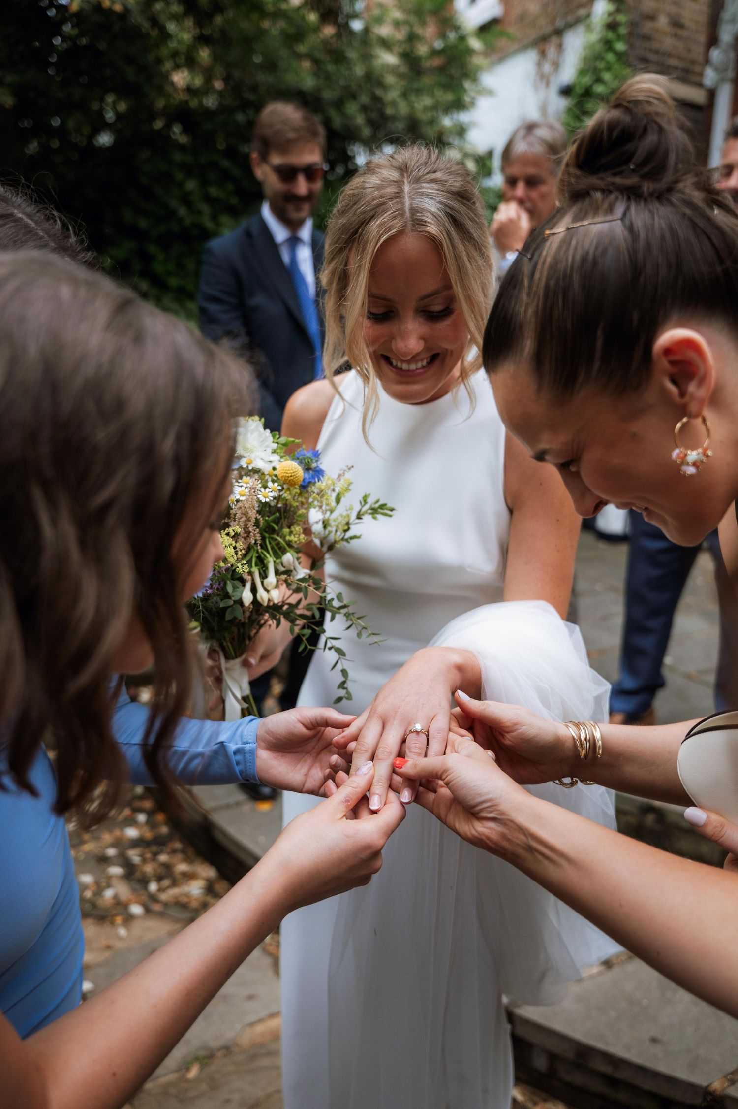 A series of close-up shots showing hands exchanging rings during an outdoor wedding ceremony.