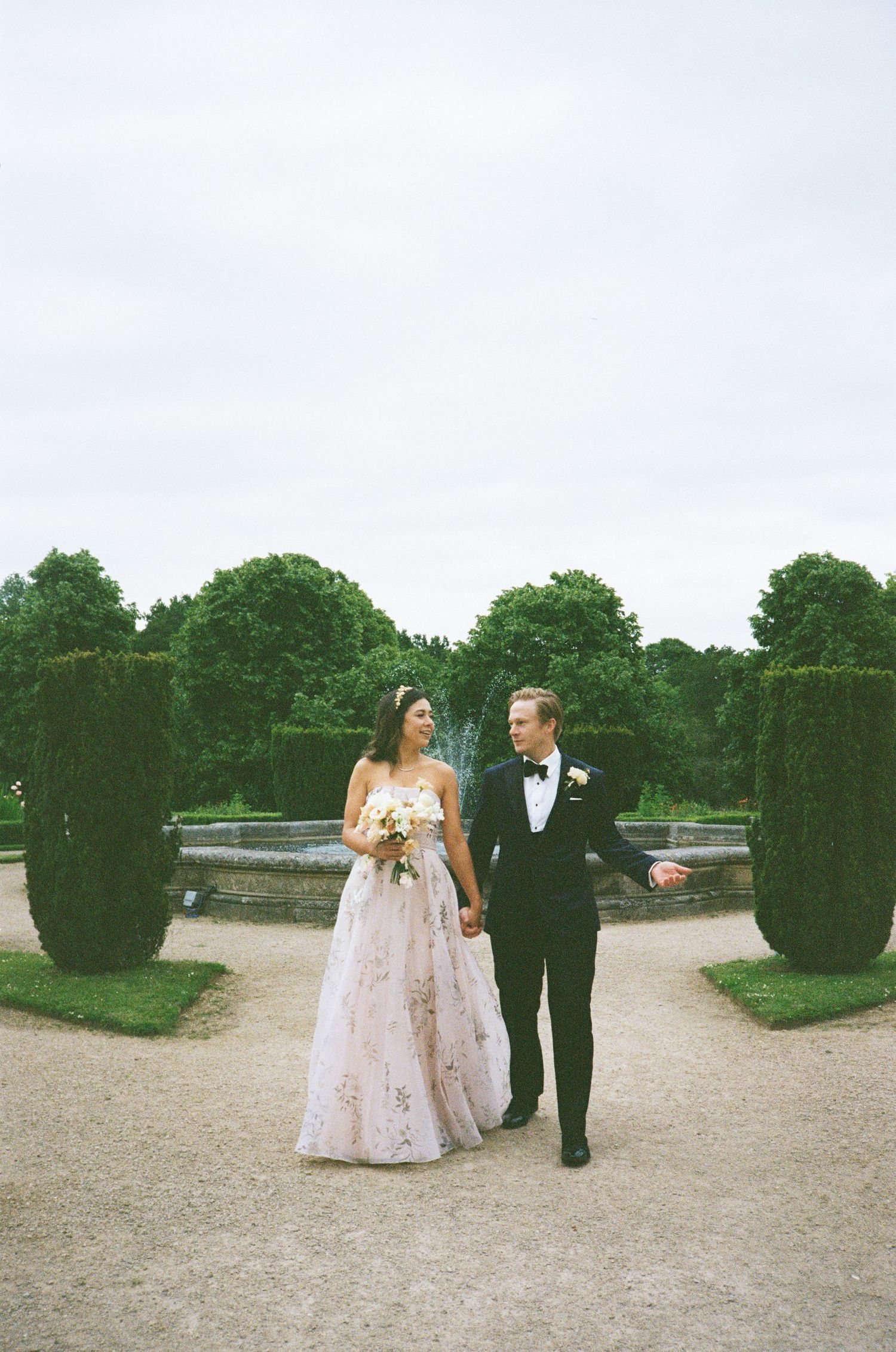 Newly married couple having there portrait taken in front of the fountains at Ashridge House, taken on 35mm film.