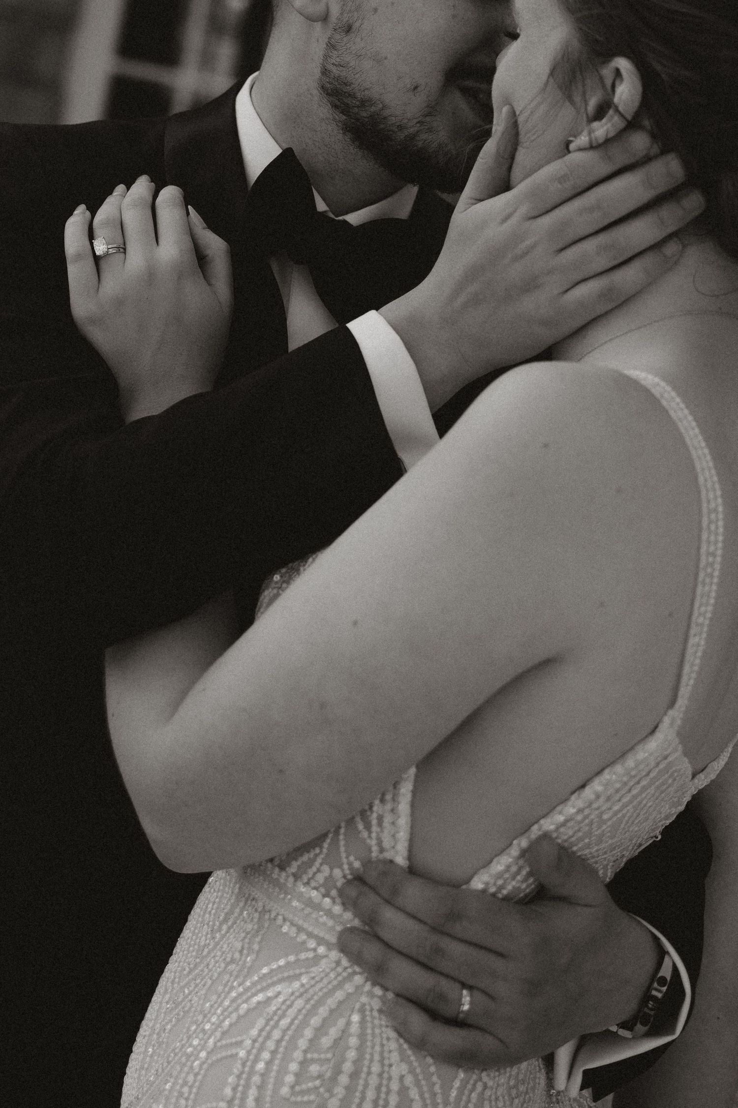 Black and white romantic photos show intimate moments between a couple in formal wedding attire embracing.