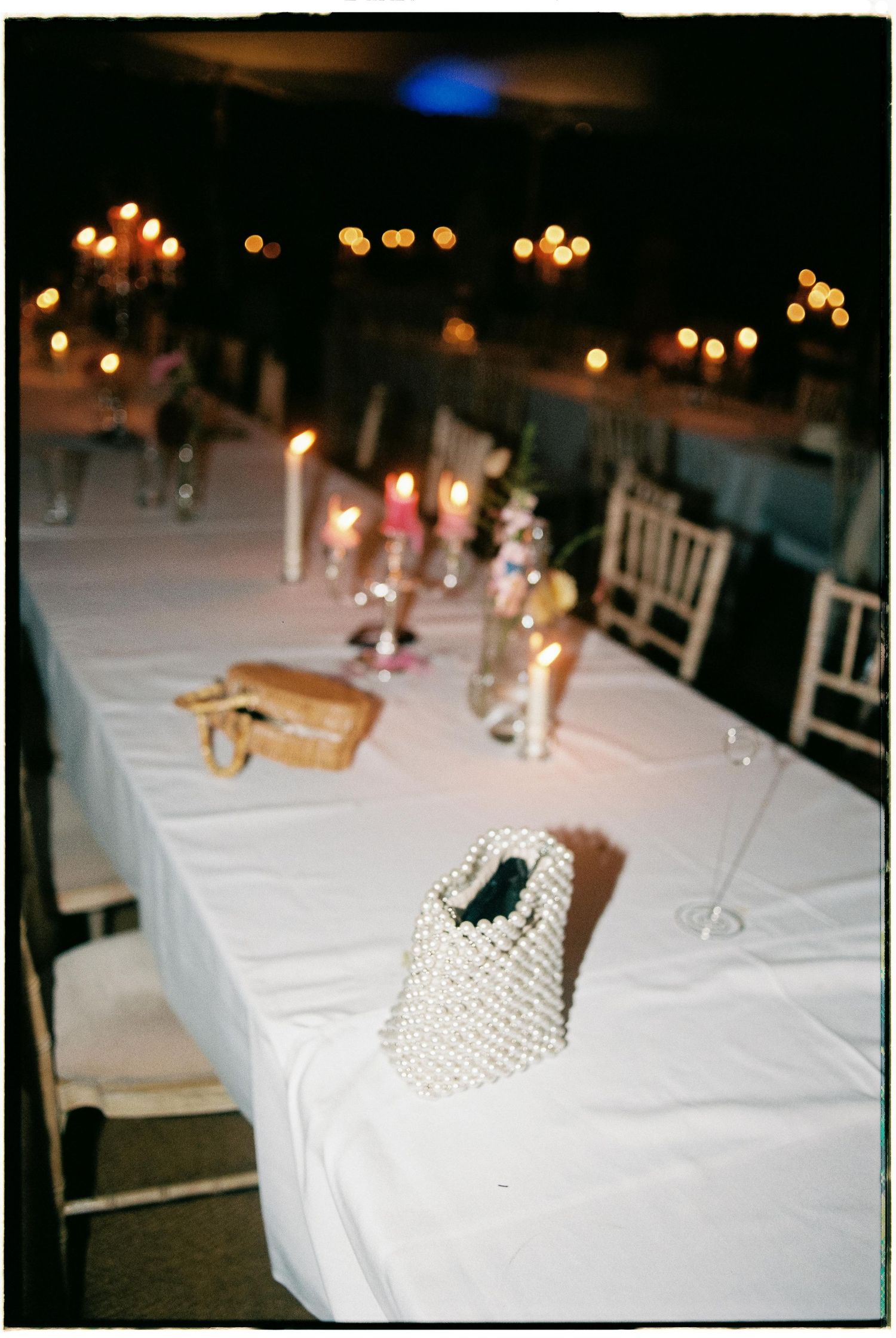 A series of elegant table settings at a formal event with white linens and soft lighting in the background.