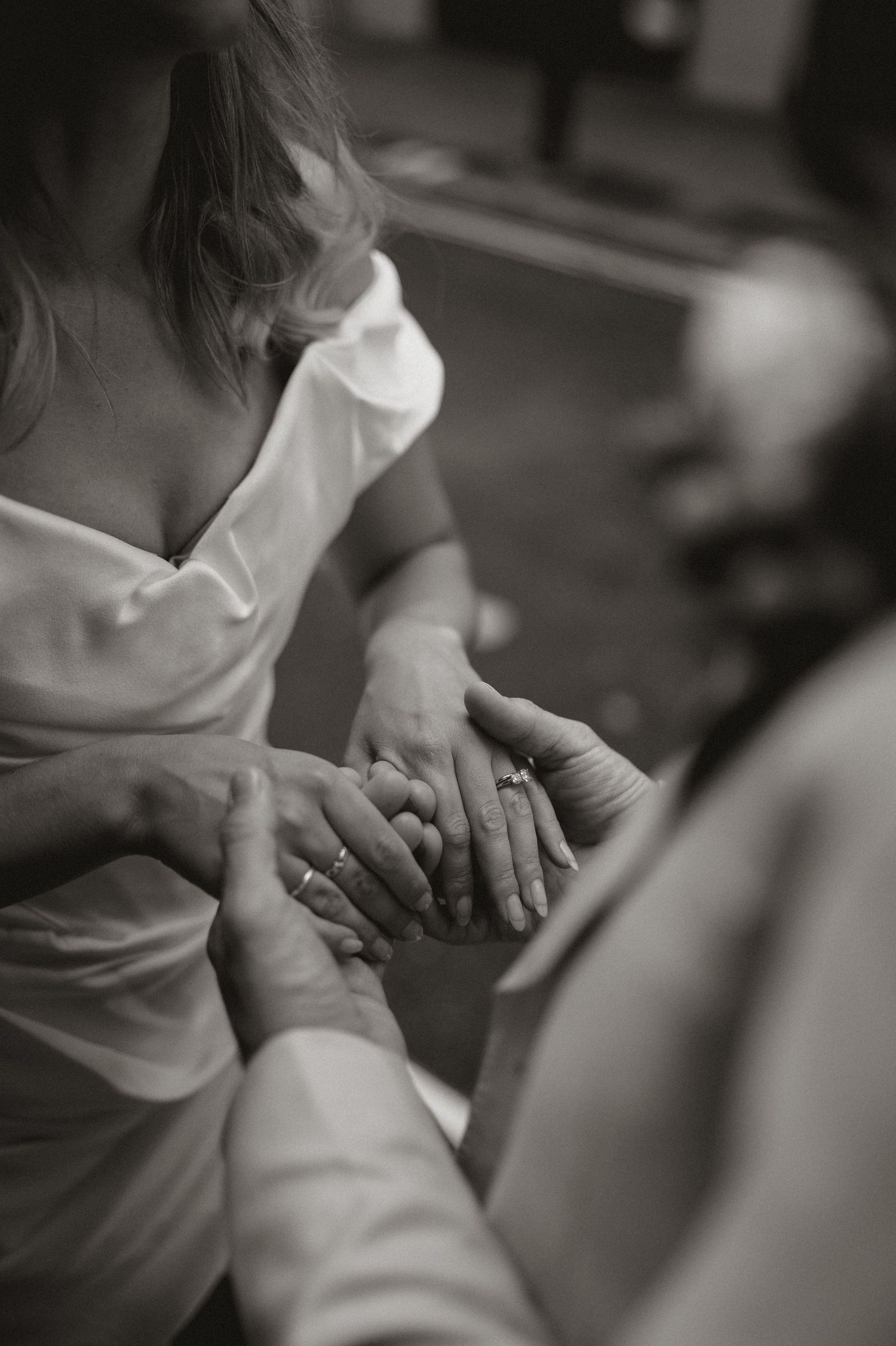Close-up black and white images showing hands holding and interacting in a sequence.
