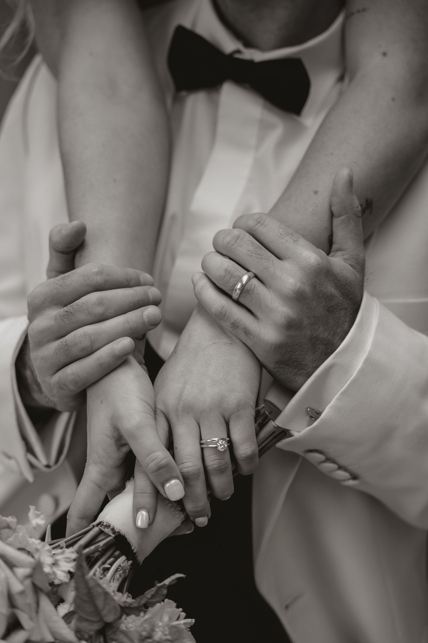 Black and white close-up photos showing hands with wedding rings in various intimate poses.