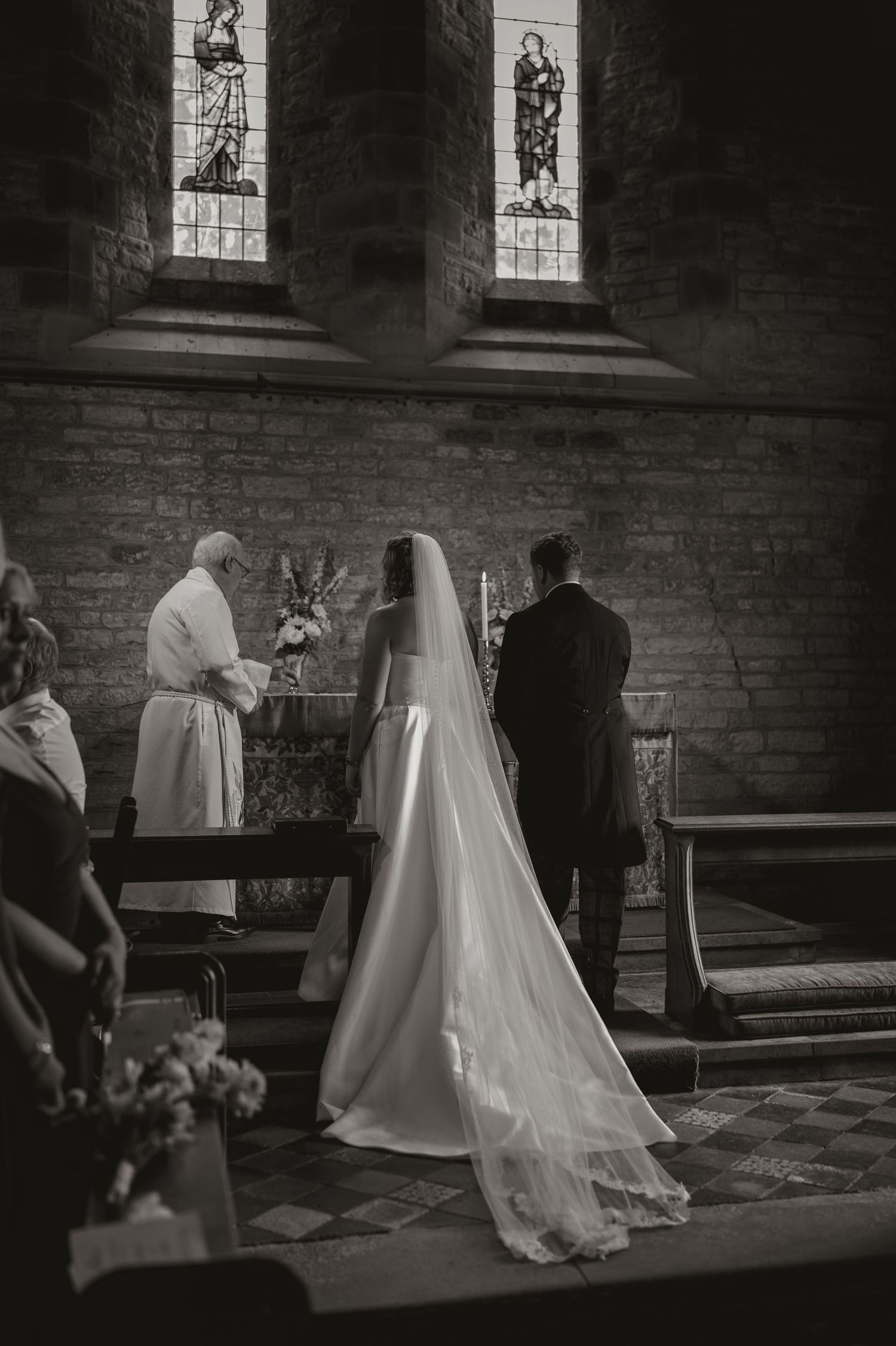 A black and white wedding ceremony sequence shows the progression of a couple kneeling at the altar in a church.
