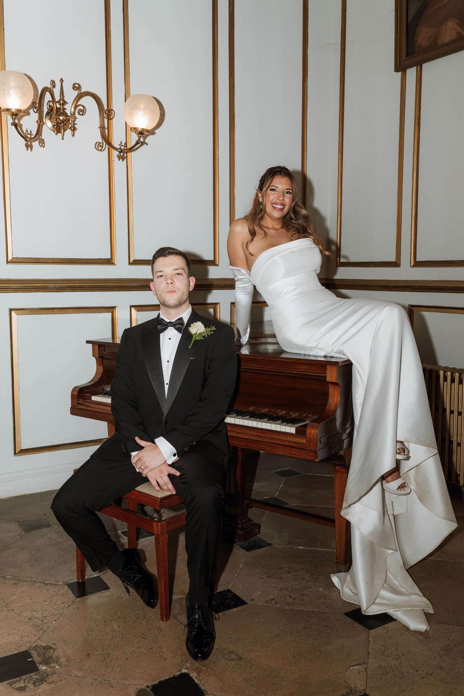 Elegant wedding photo series showing playful moments with bride and groom near a grand piano in a formal room.