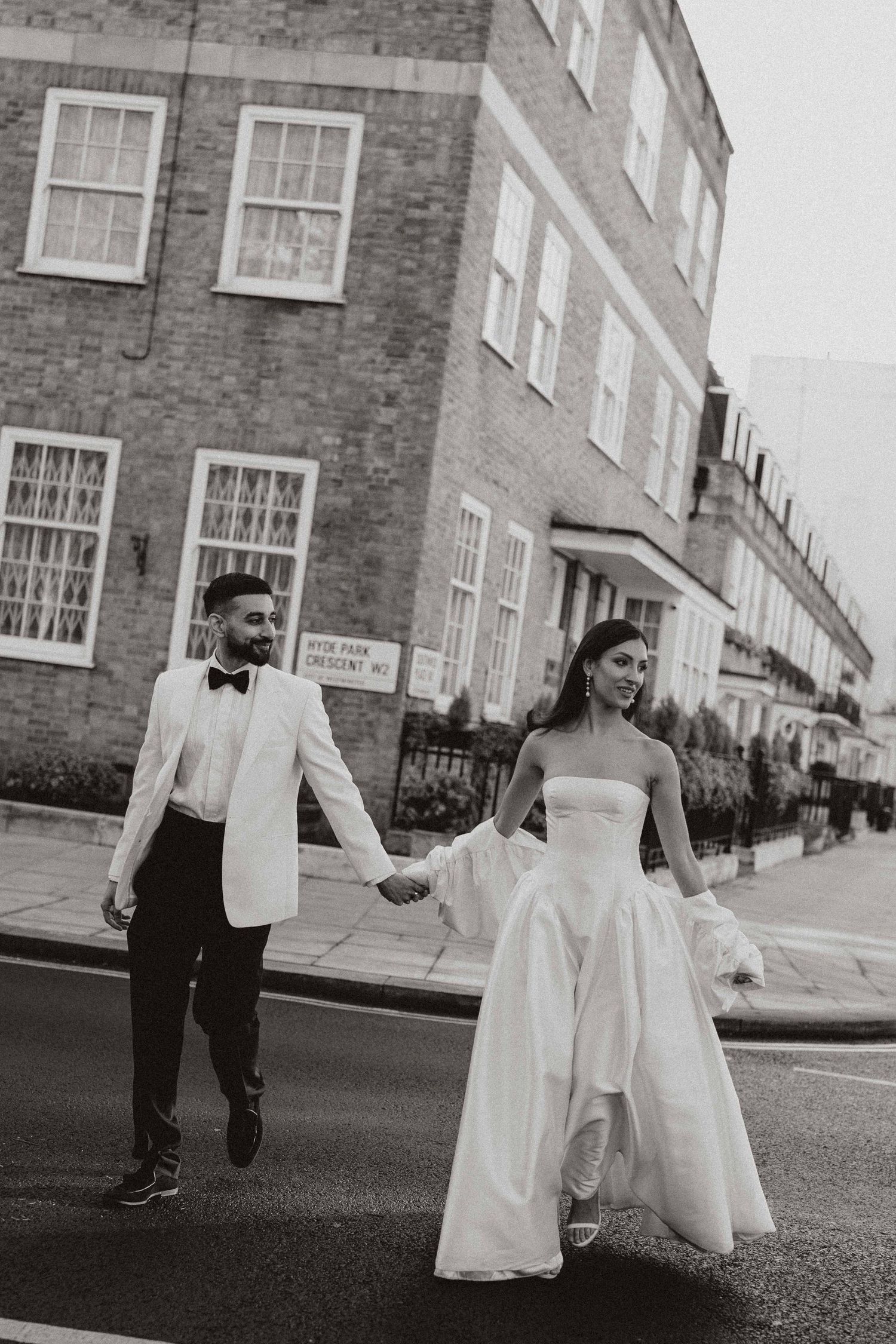 A series of black and white wedding photos showing a couple walking and posing together on a city street.