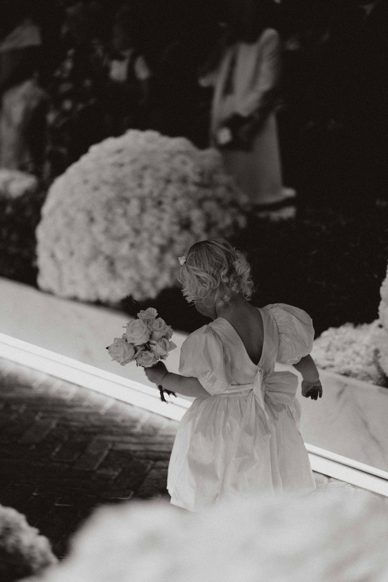 Black and white photograph of cherub statues and floral arrangements decorating a wedding ceremony setting.