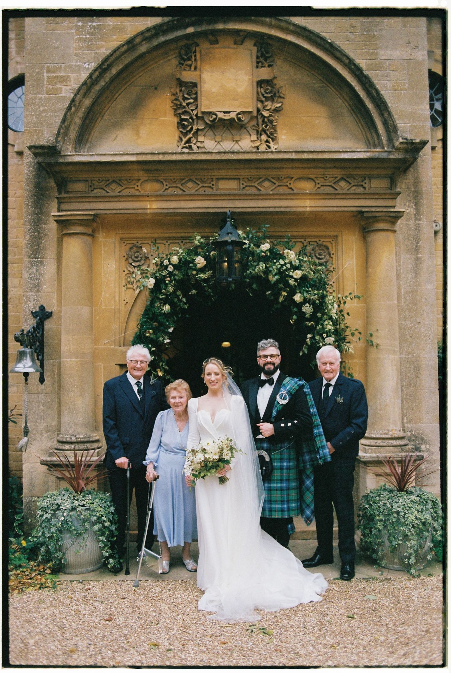 A series of wedding photographs taken at an elegant stone building entrance with decorative archways and greenery.