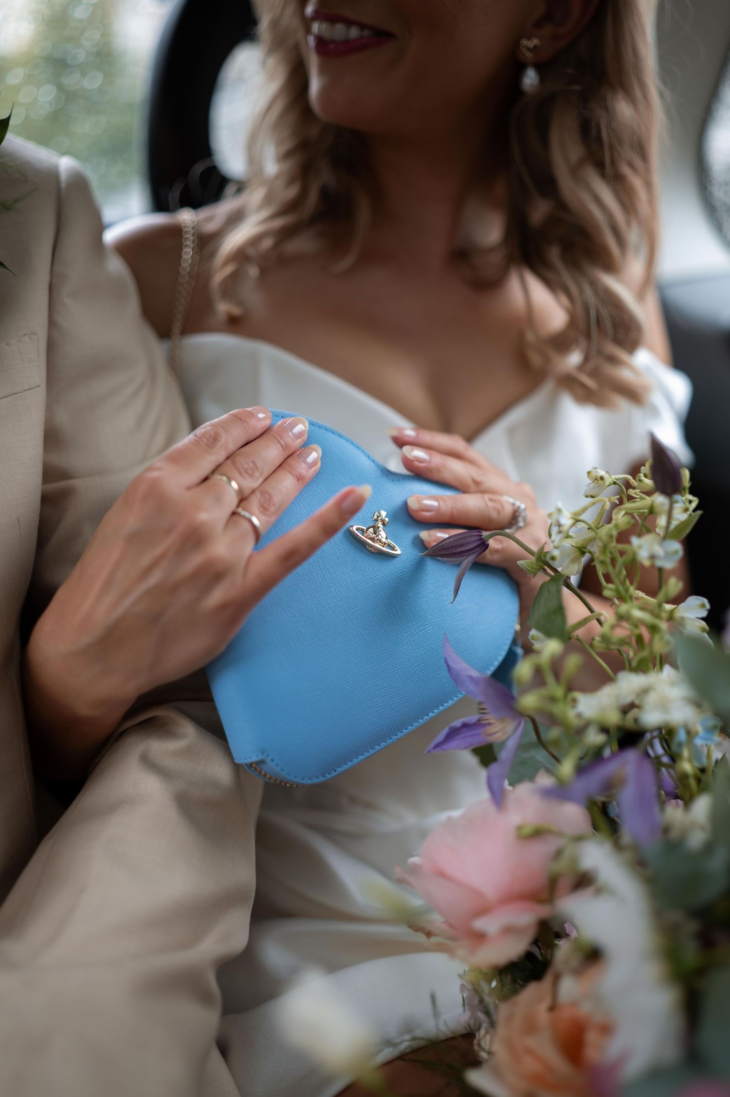 A teapot pouring liquid into a teacup with flowers in the foreground at a formal event.