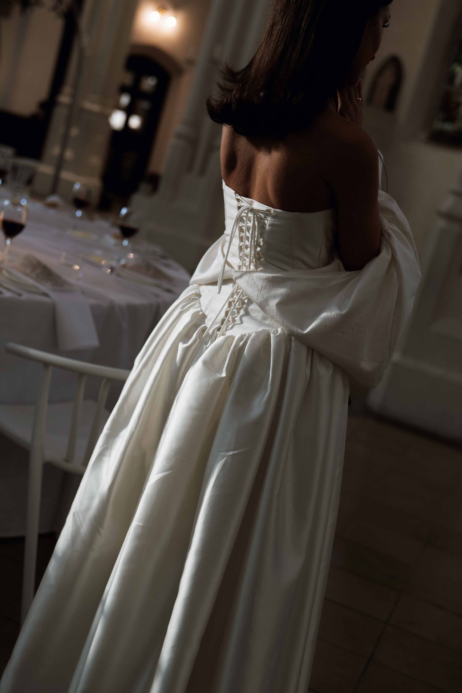 Close-up view of a white high-neck Victorian style dress with delicate ruffles and pleating details.