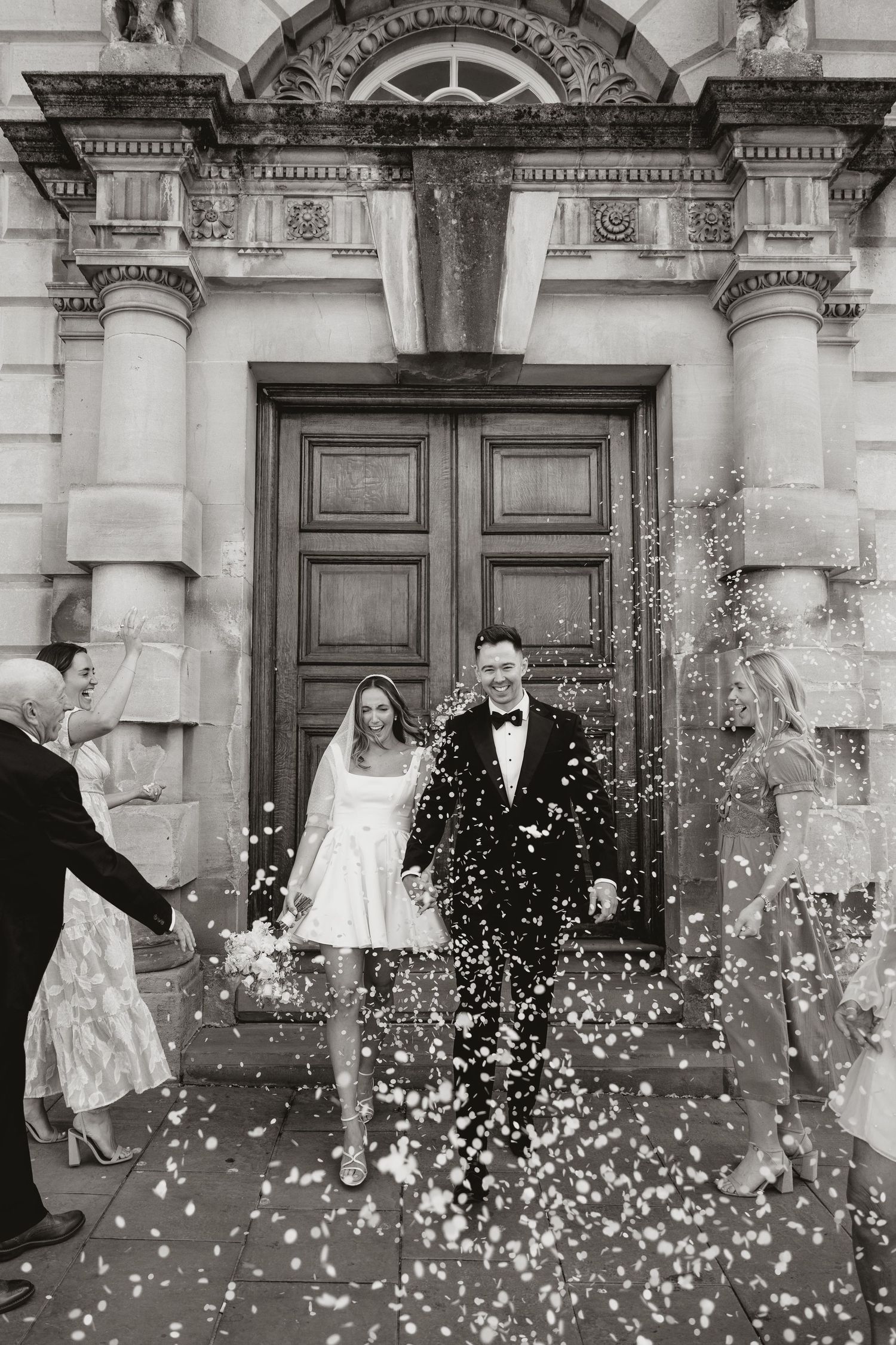 Black and white photo sequence showing a couple celebrating with flower petals being thrown at them outside an ornate building.