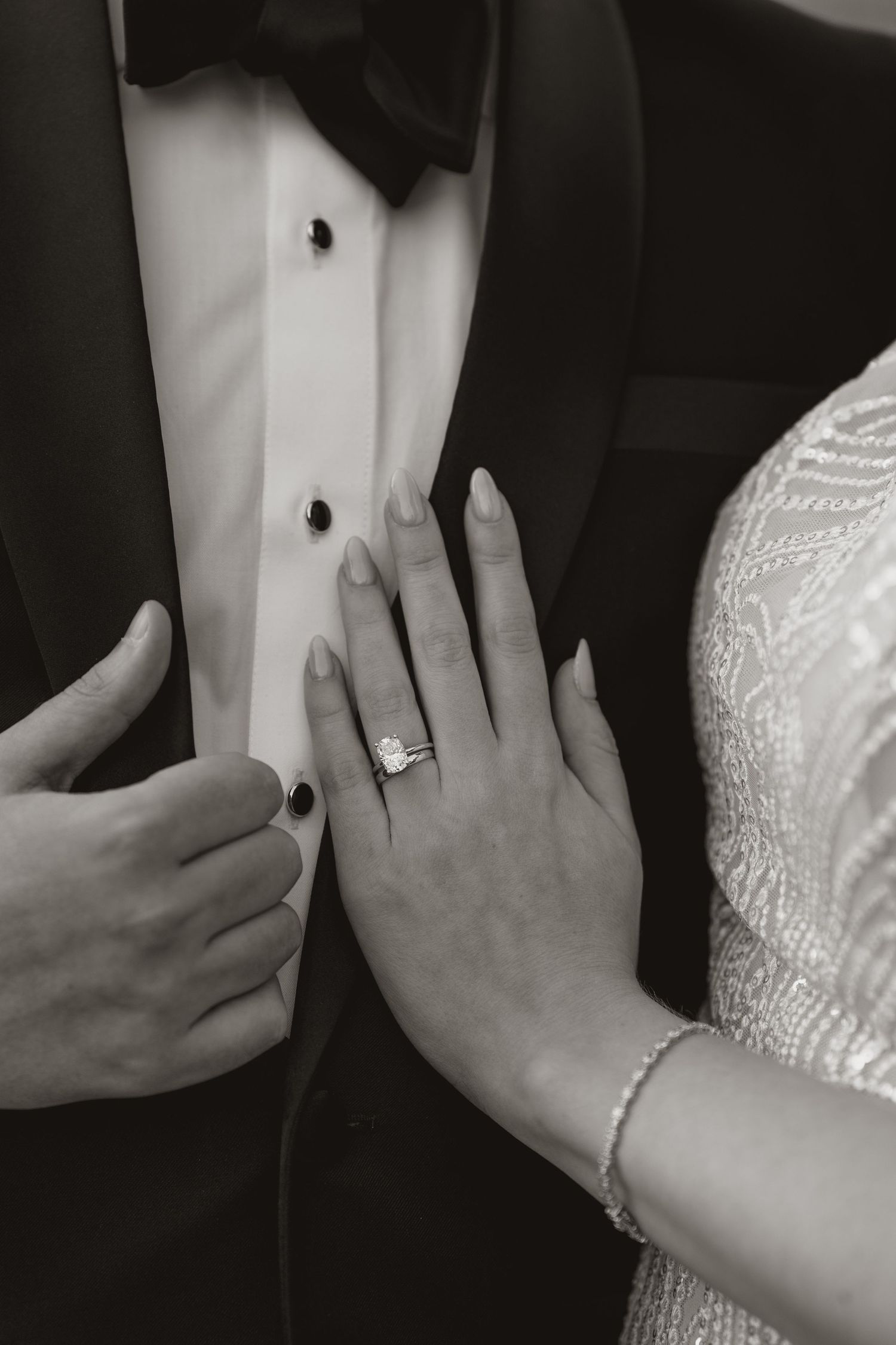 Close-up sequence showing newlyweds hands exchanging rings during a wedding ceremony in black and white.