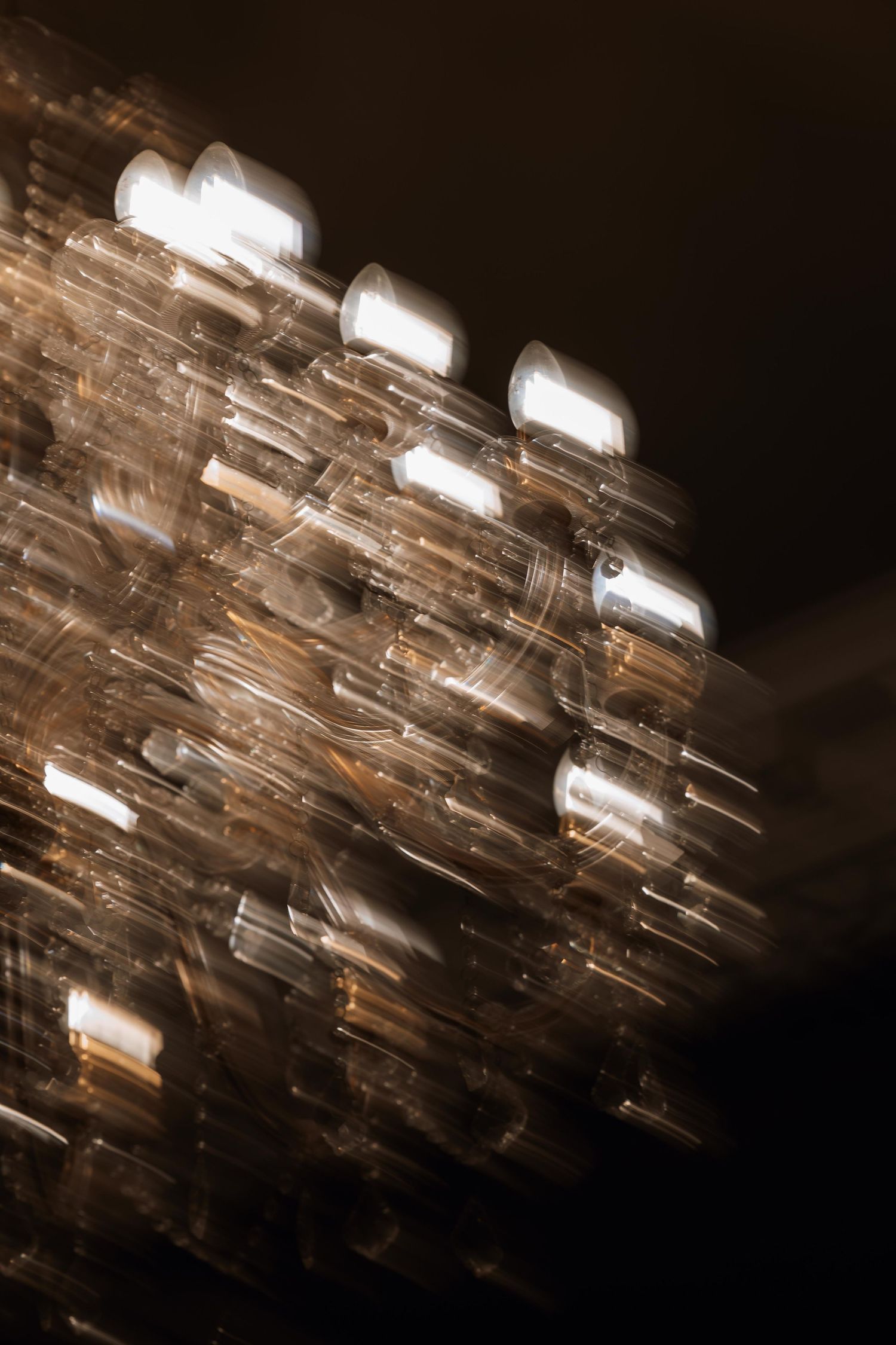 Abstract pattern of light reflections creating diagonal streaks against a dark background in sepia tones.