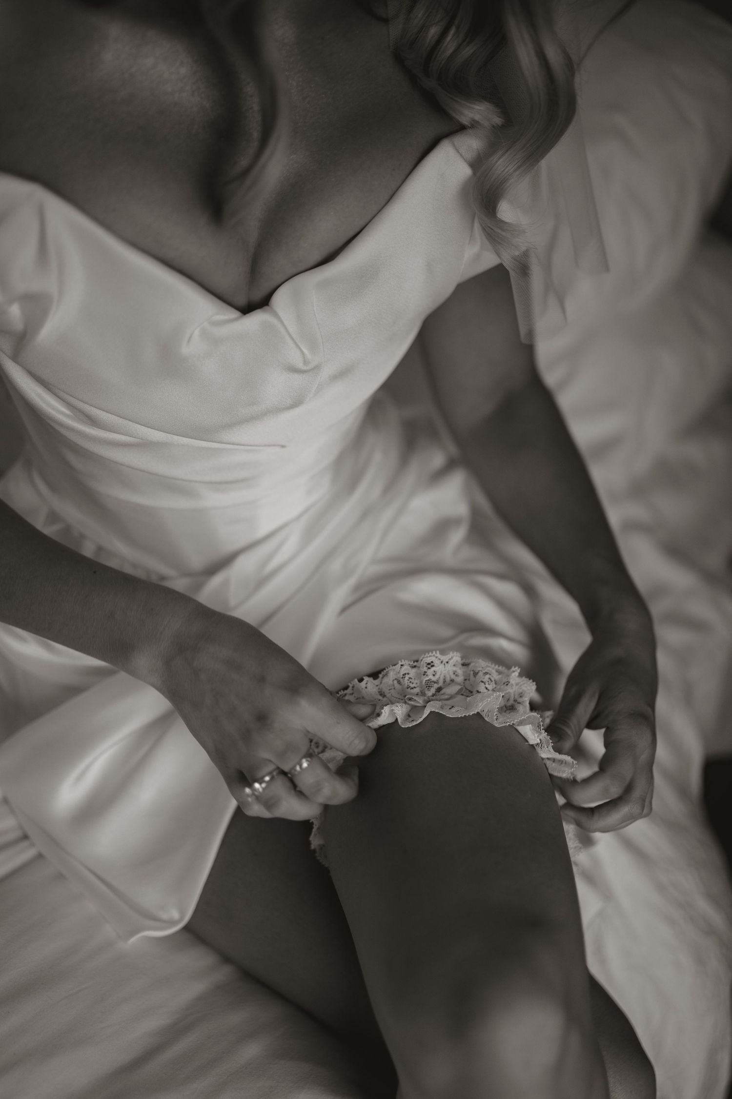 Black and white closeup images of a bride's wedding dress details showing delicate lace and fabric textures.