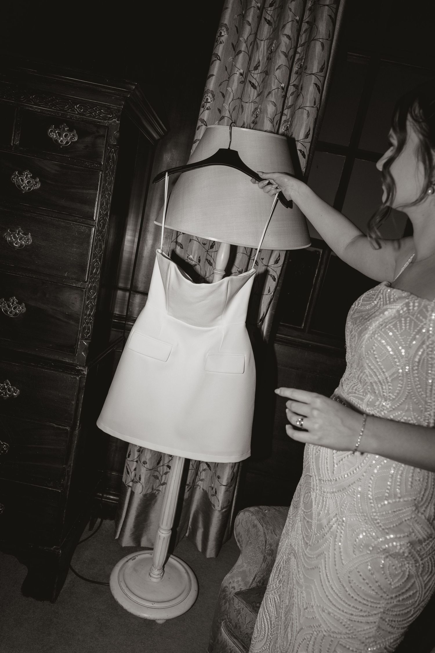 A sequence of black and white photos showing someone adjusting a white table lamp in a dimly lit room.