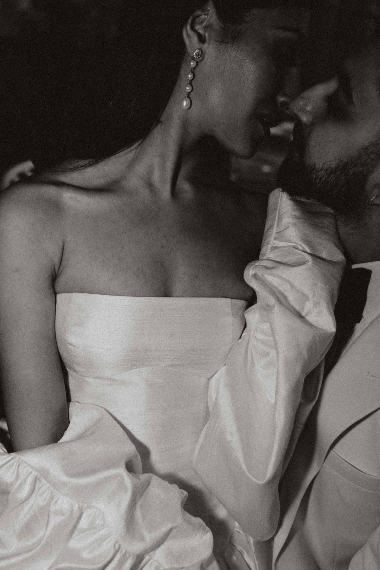 a couple sharing a close intimate moment, she’s sitting on his lap whilst kissing.