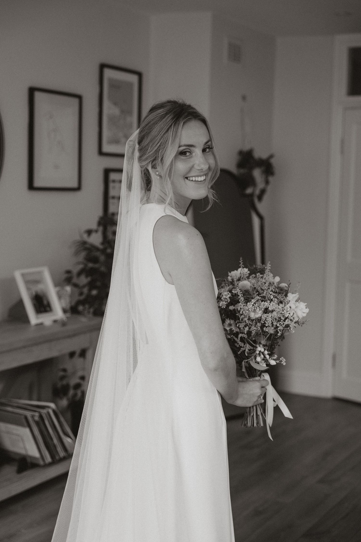 A sequence of black and white photos showing a bride in her wedding dress holding a floral bouquet indoors.