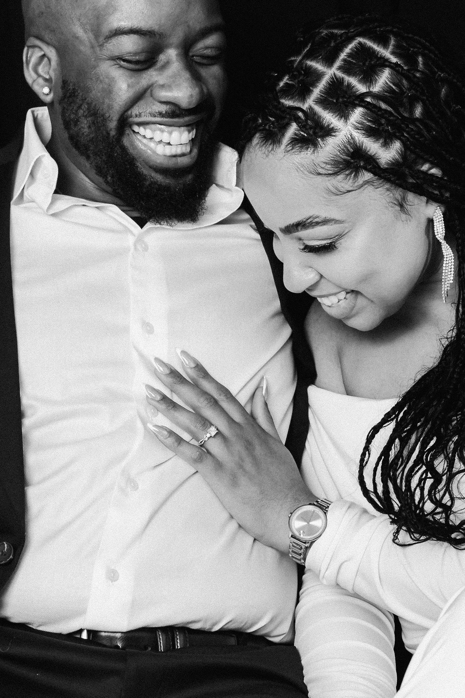 A joyful black and white photo capturing a romantic moment between two people laughing and embracing.