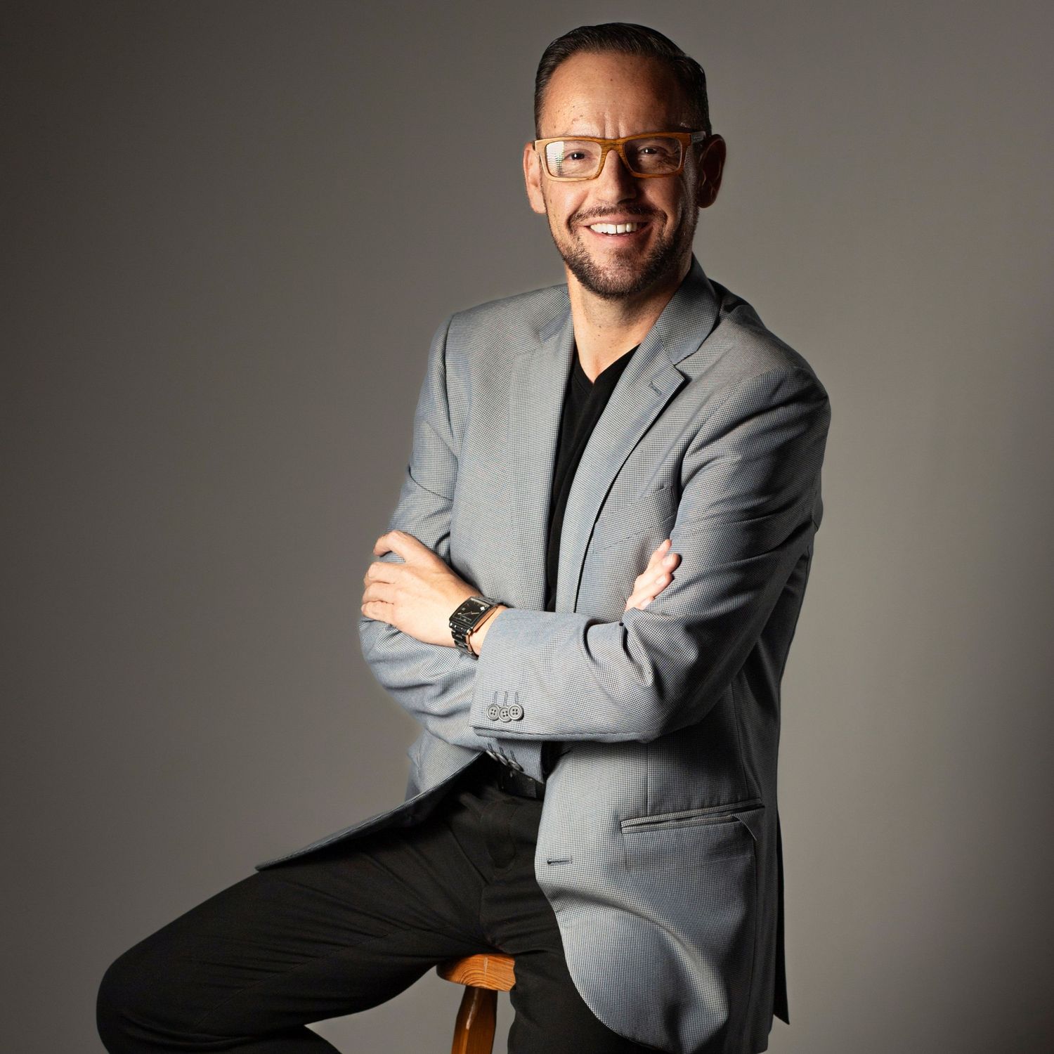 Professional studio portrait series showing a person in a gray suit jacket smiling and posing against a neutral background.