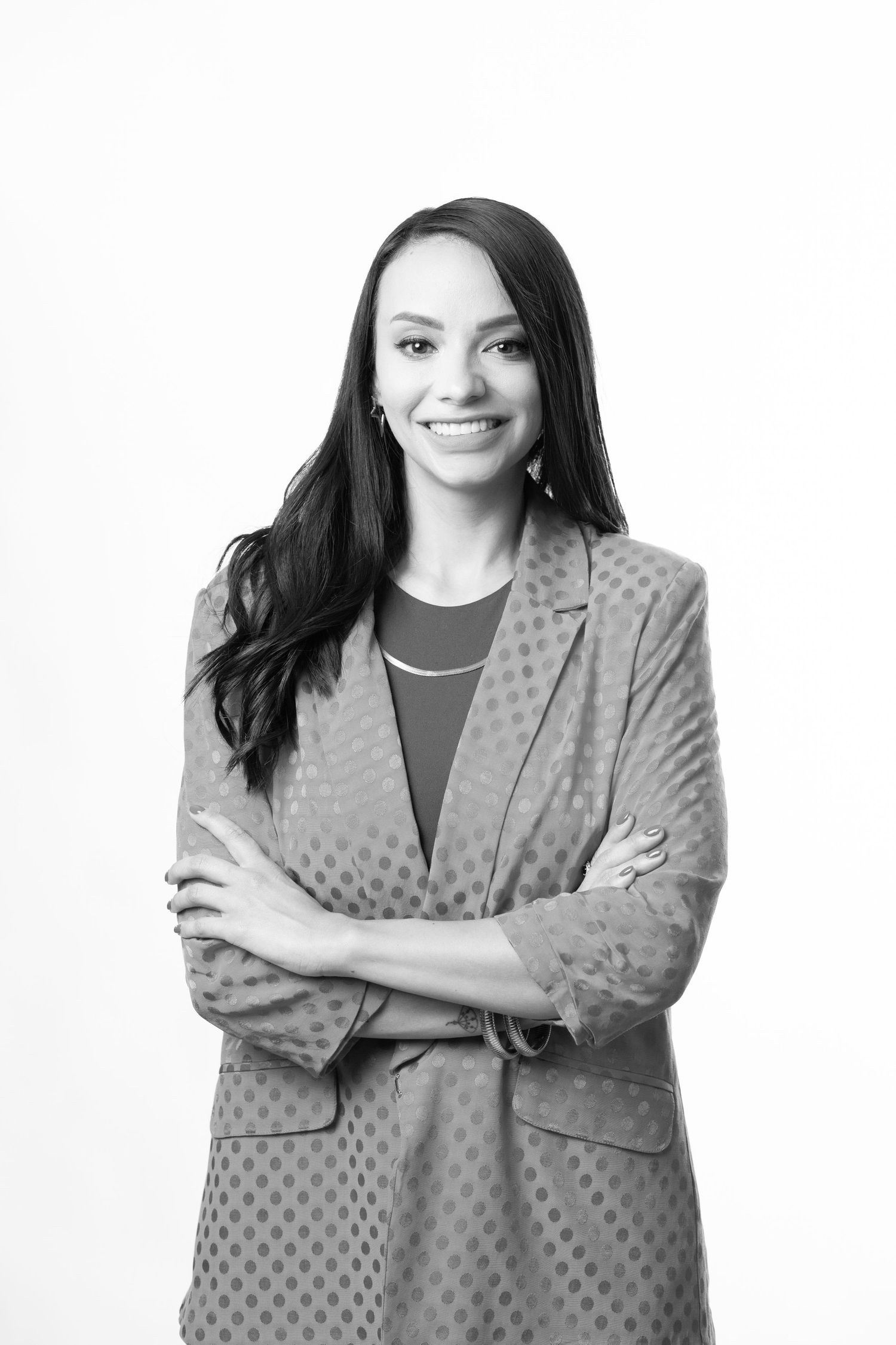Professional woman in gray polka dot blazer shown in three similar poses with arms crossed and confident smile.