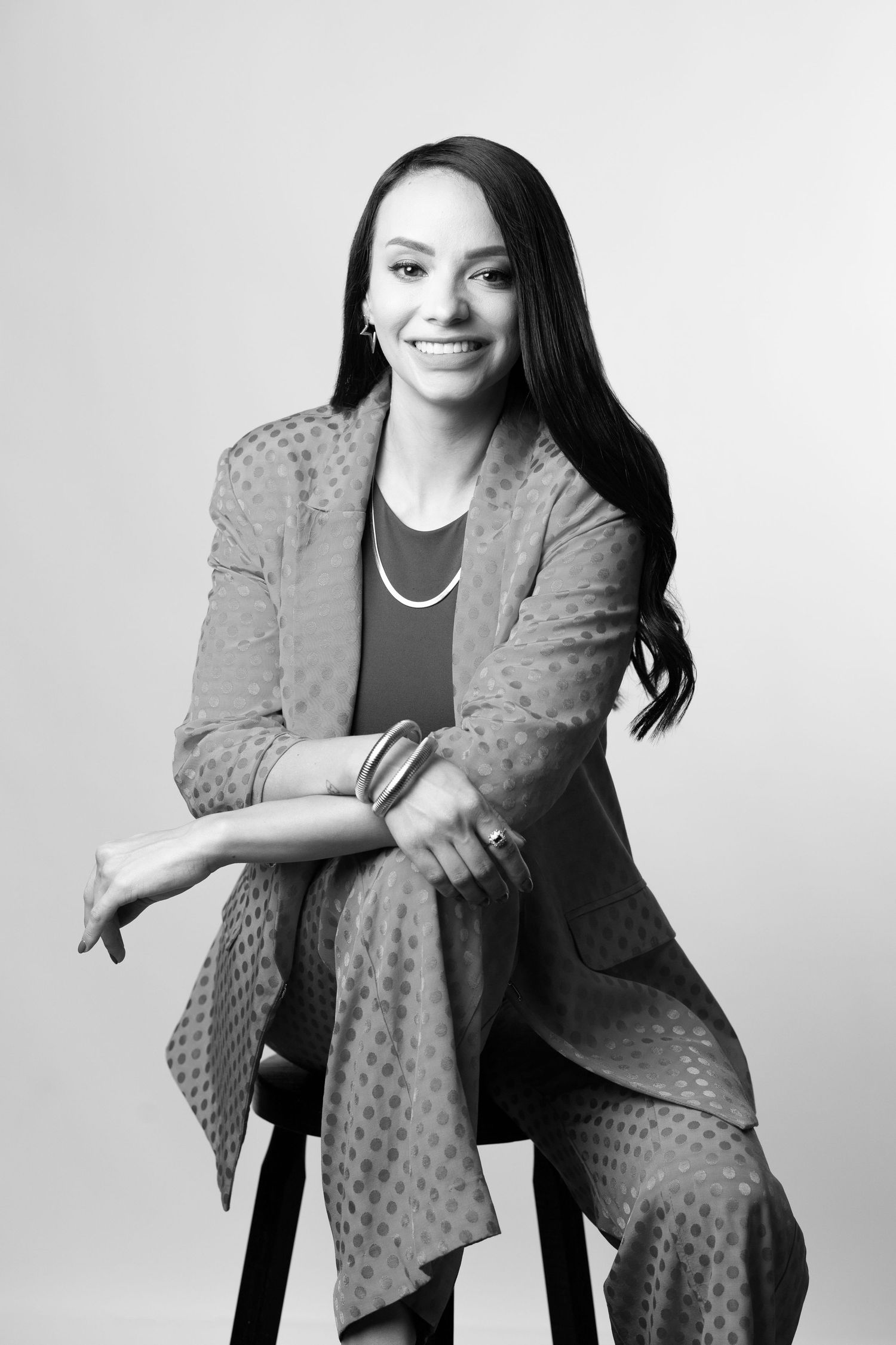 Professional black and white photo series showing a person in a polka dot blazer posing expressively against white background.