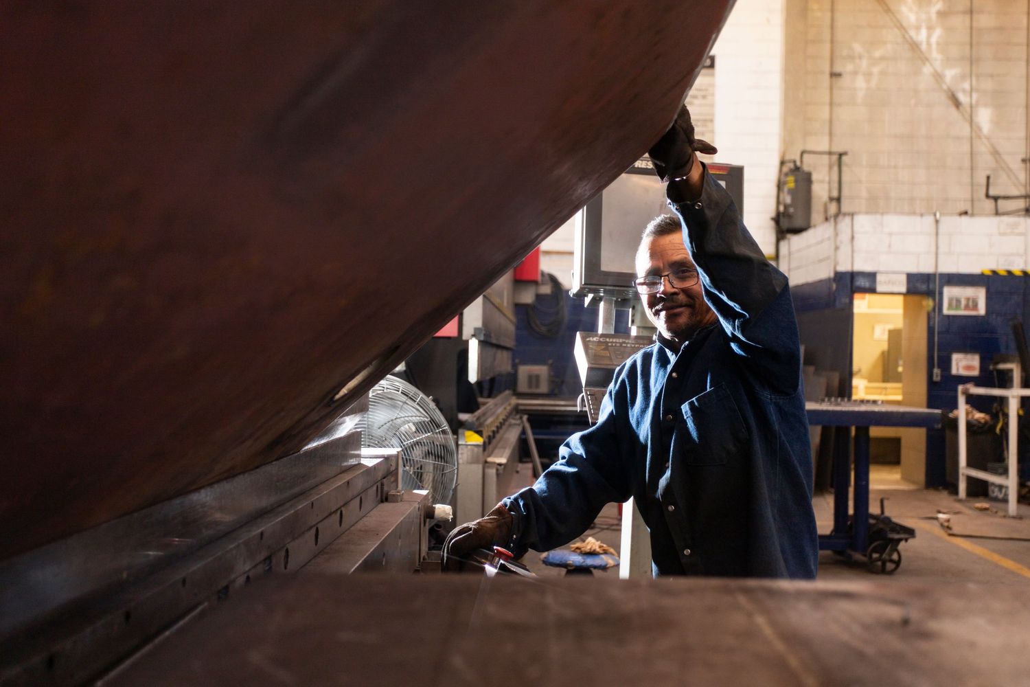 A sequence of images showing someone working on a large curved metal surface in an industrial workshop setting.