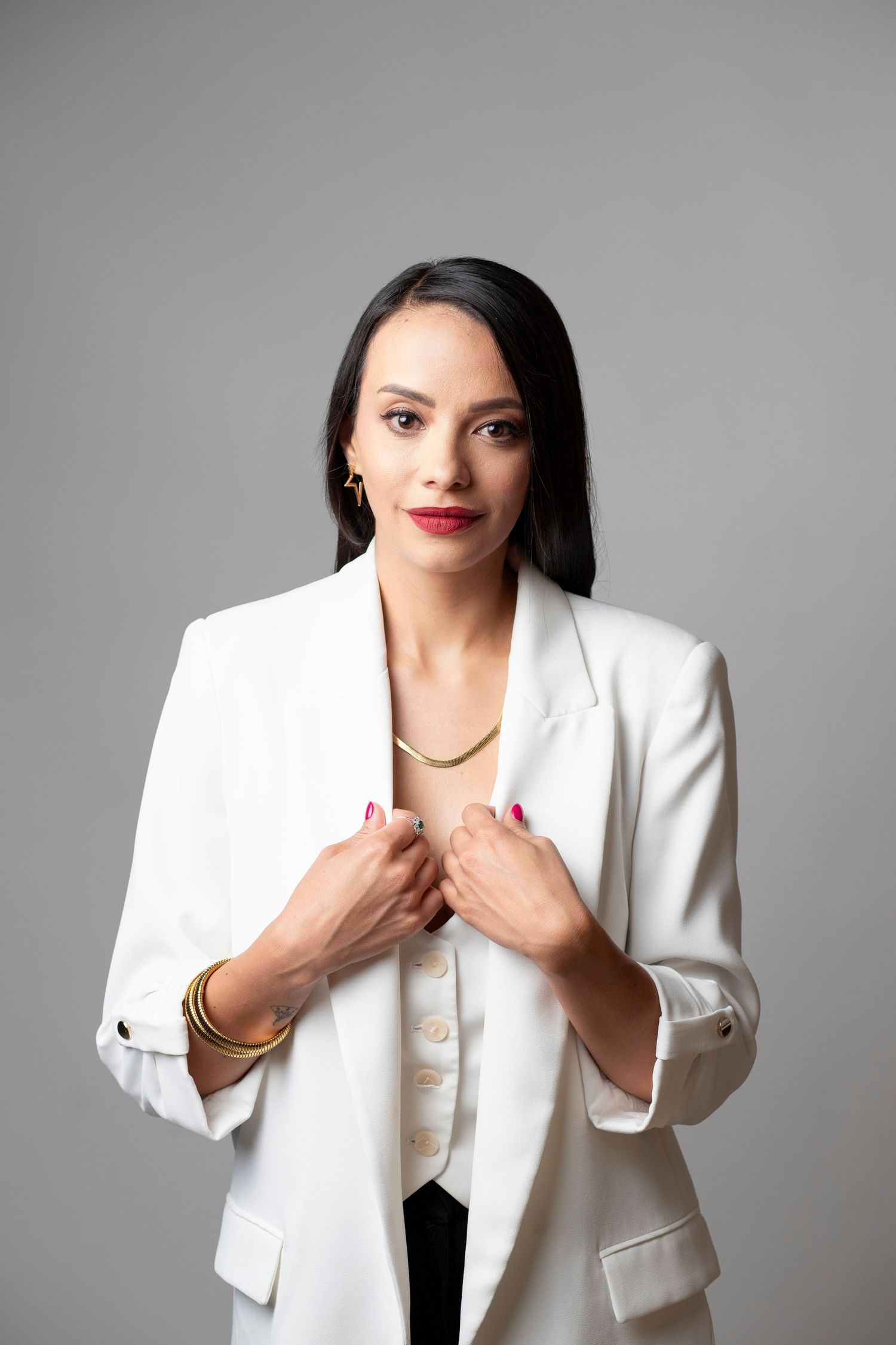 A series of fashion portraits showing someone in a white blazer and black top against a gray background.
