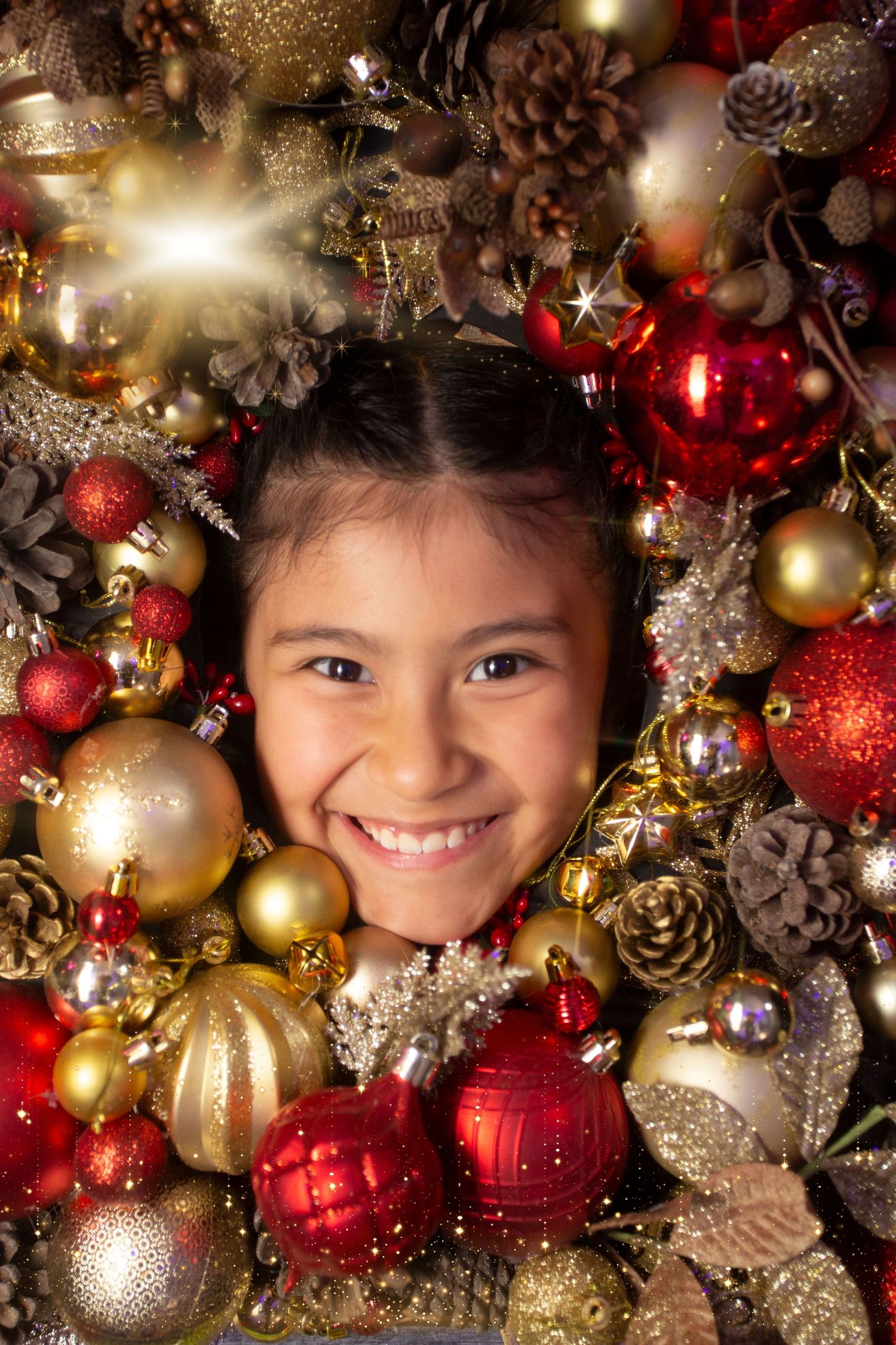 Festive Christmas decorations with gold and red ornaments, pinecones, and glittery baubles create a magical holiday display.