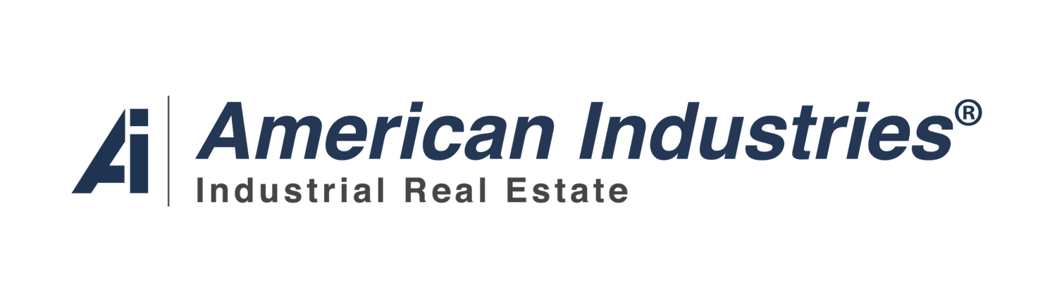 A modern American Industries company logo in dark blue with an abstract geometric triangle shape.