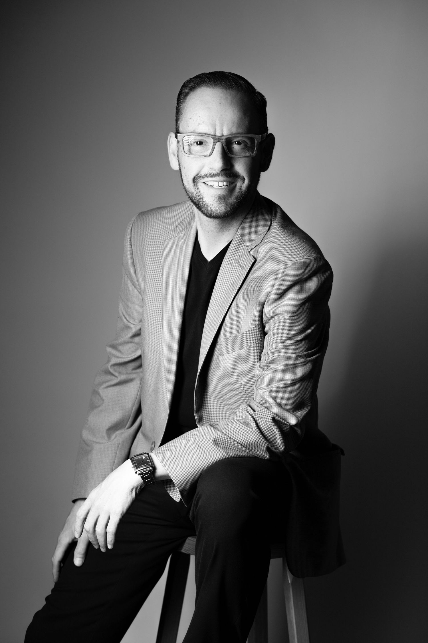 Professional black and white portrait series showing a person in a light blazer and dark shirt against a gray background.