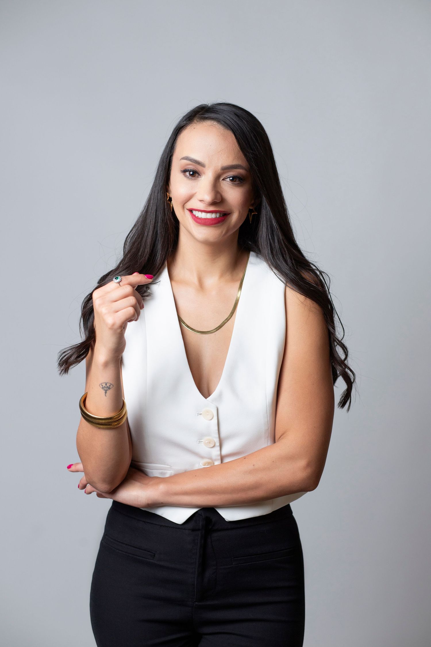Professional studio portrait series of someone in business attire with white top and black bottom against gray backdrop.
