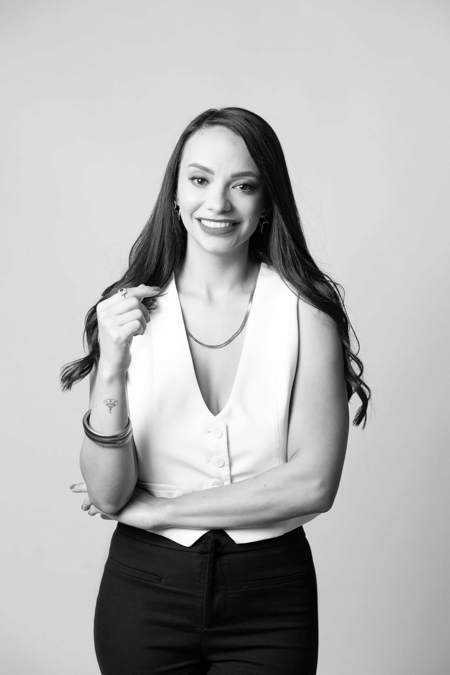 A series of black and white portraits showing someone in a white top and dark bottoms posing against a light background.