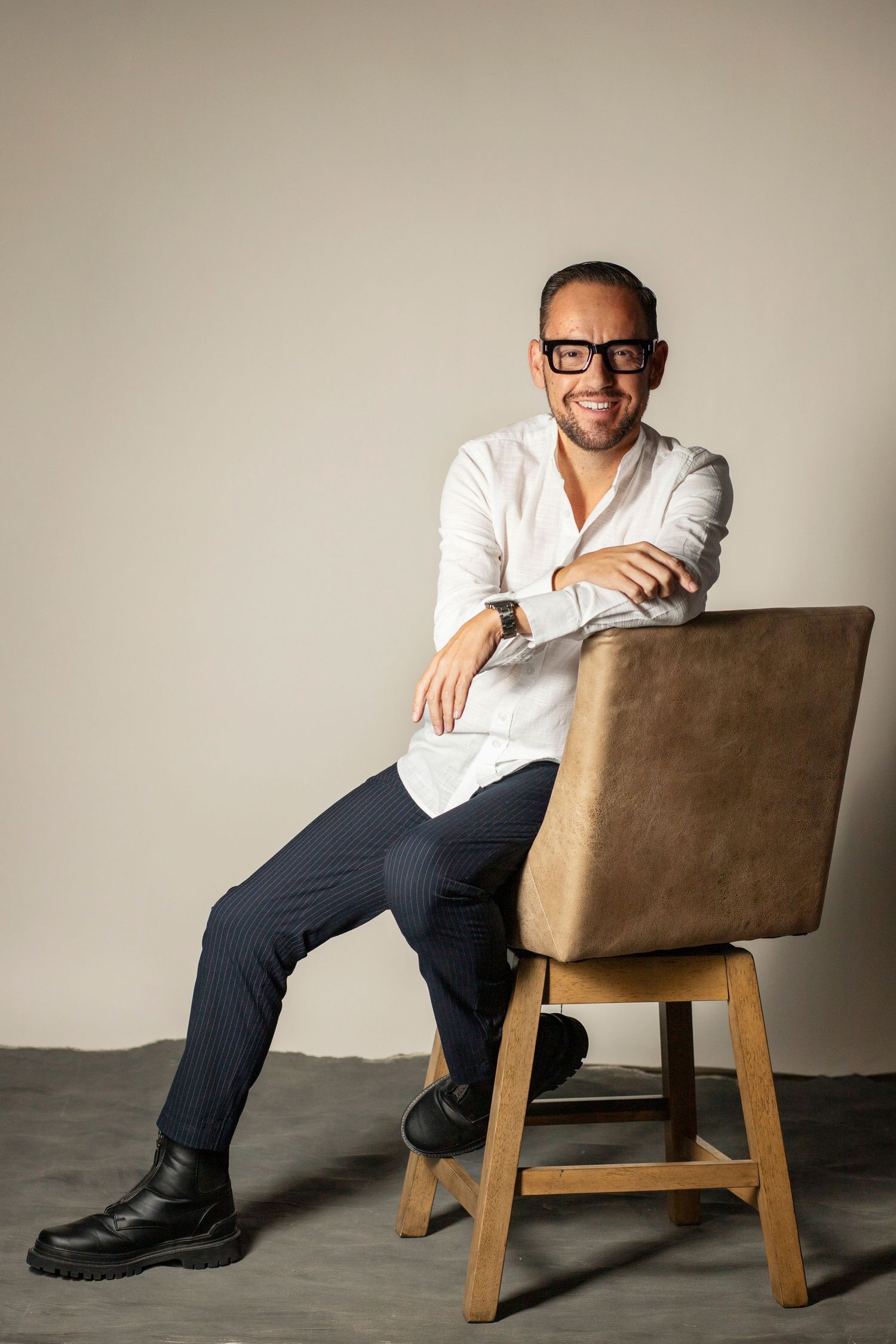 A series of photos showing someone seated in a modern tan lounge chair against a neutral wall.