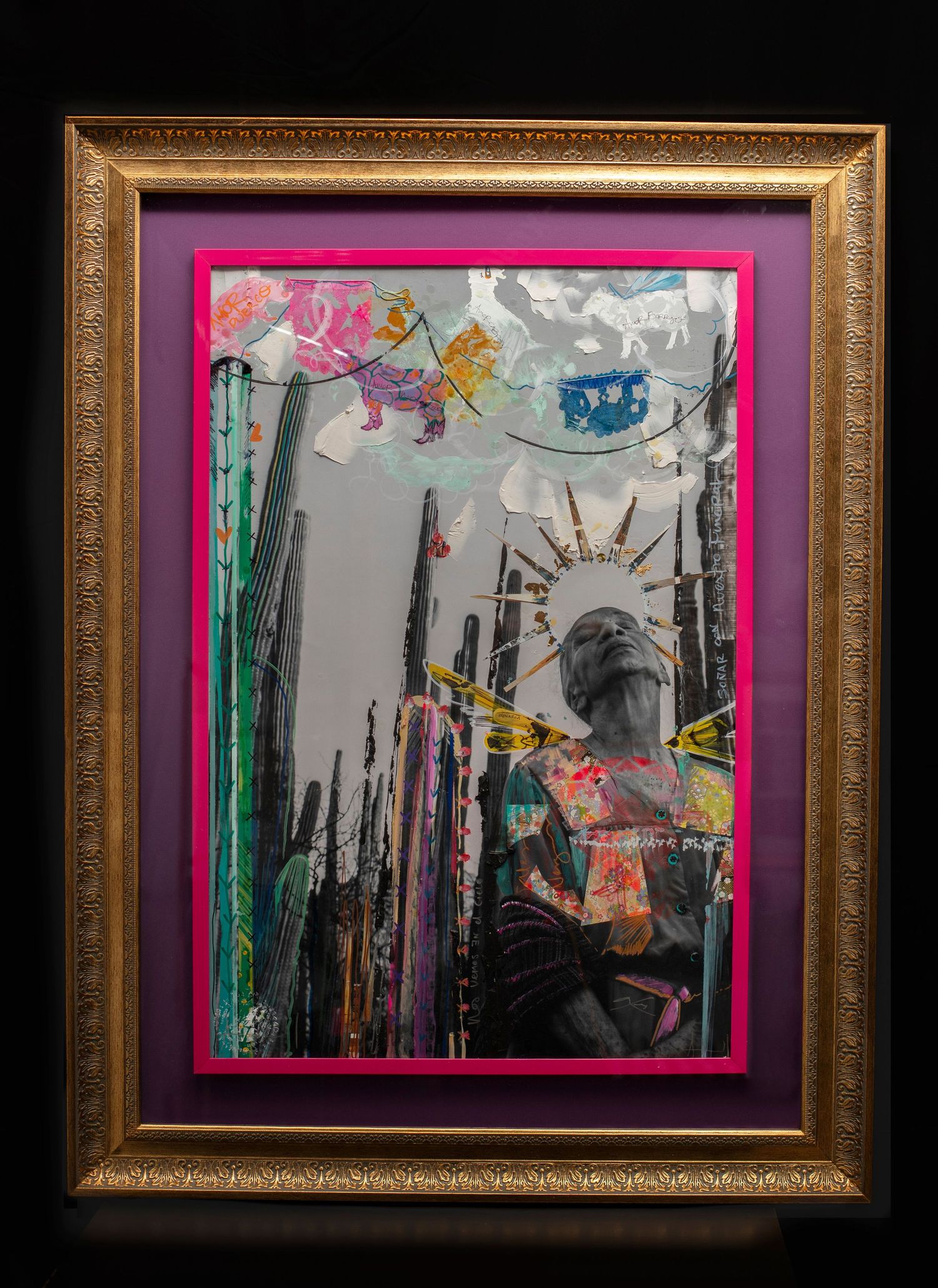 Vibrant mixed-media framed artwork featuring a figure, cacti, colorful collage elements, and pink mat in ornate gold frame.