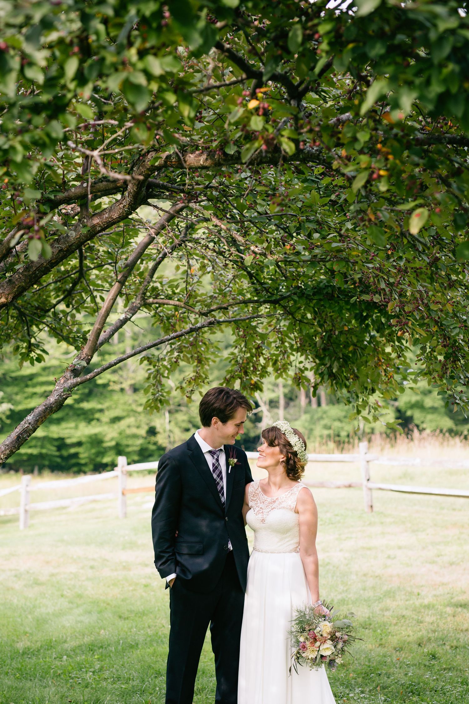 Romantic portrait beneath an apple tree on a serene summer day.