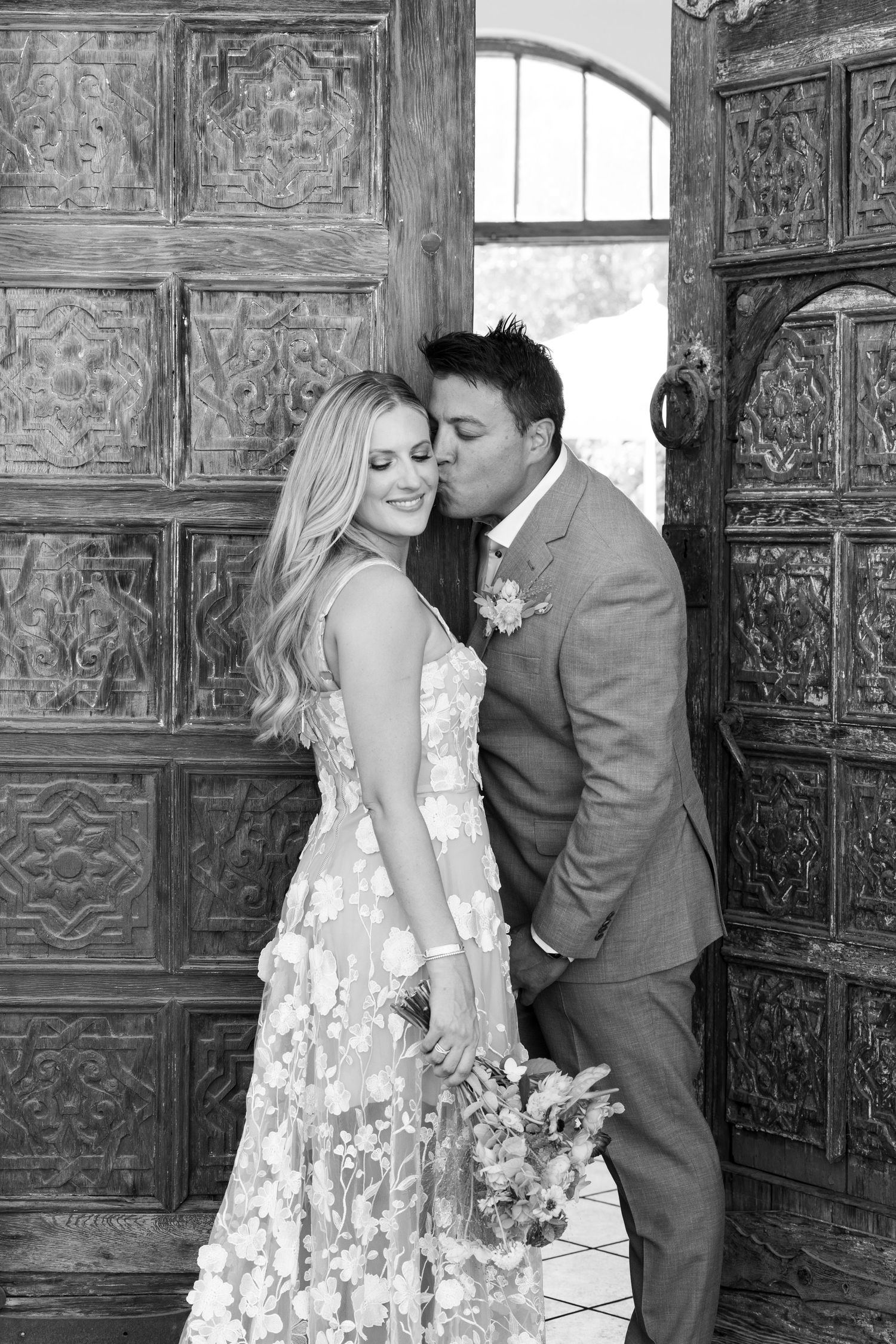A bride and groom standing at the doorway of the Korakia Hotel in Palm Springs California