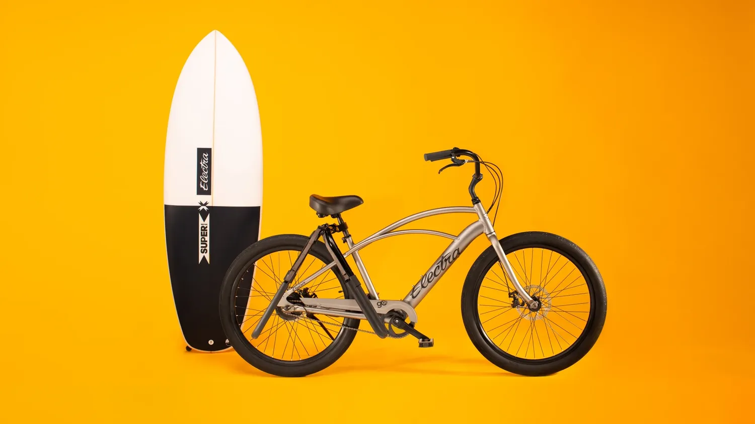 Electra bike with surfboard on yellow background
