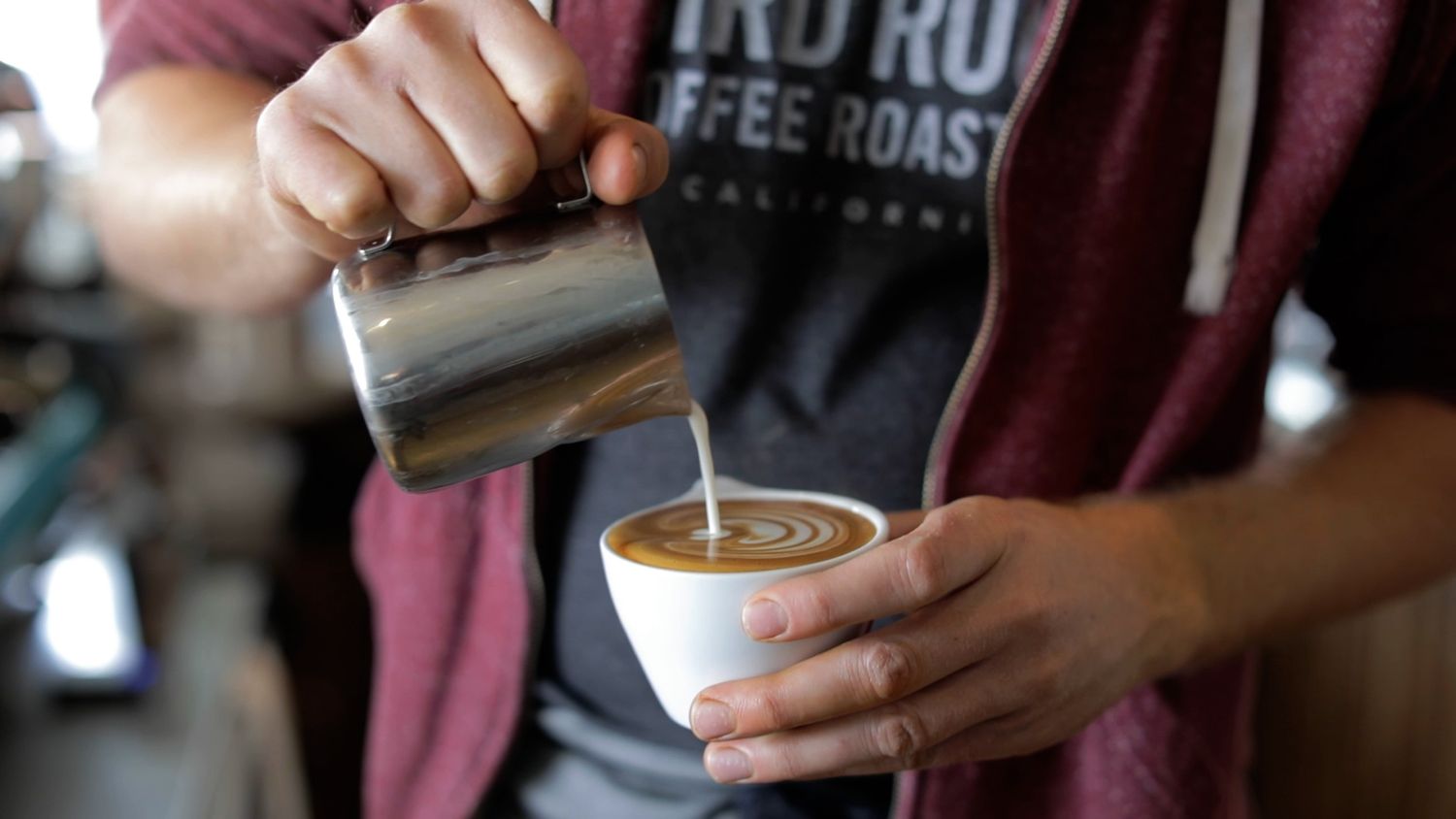 Close up photo of man making latte at Bird Rock Coffee Roasters