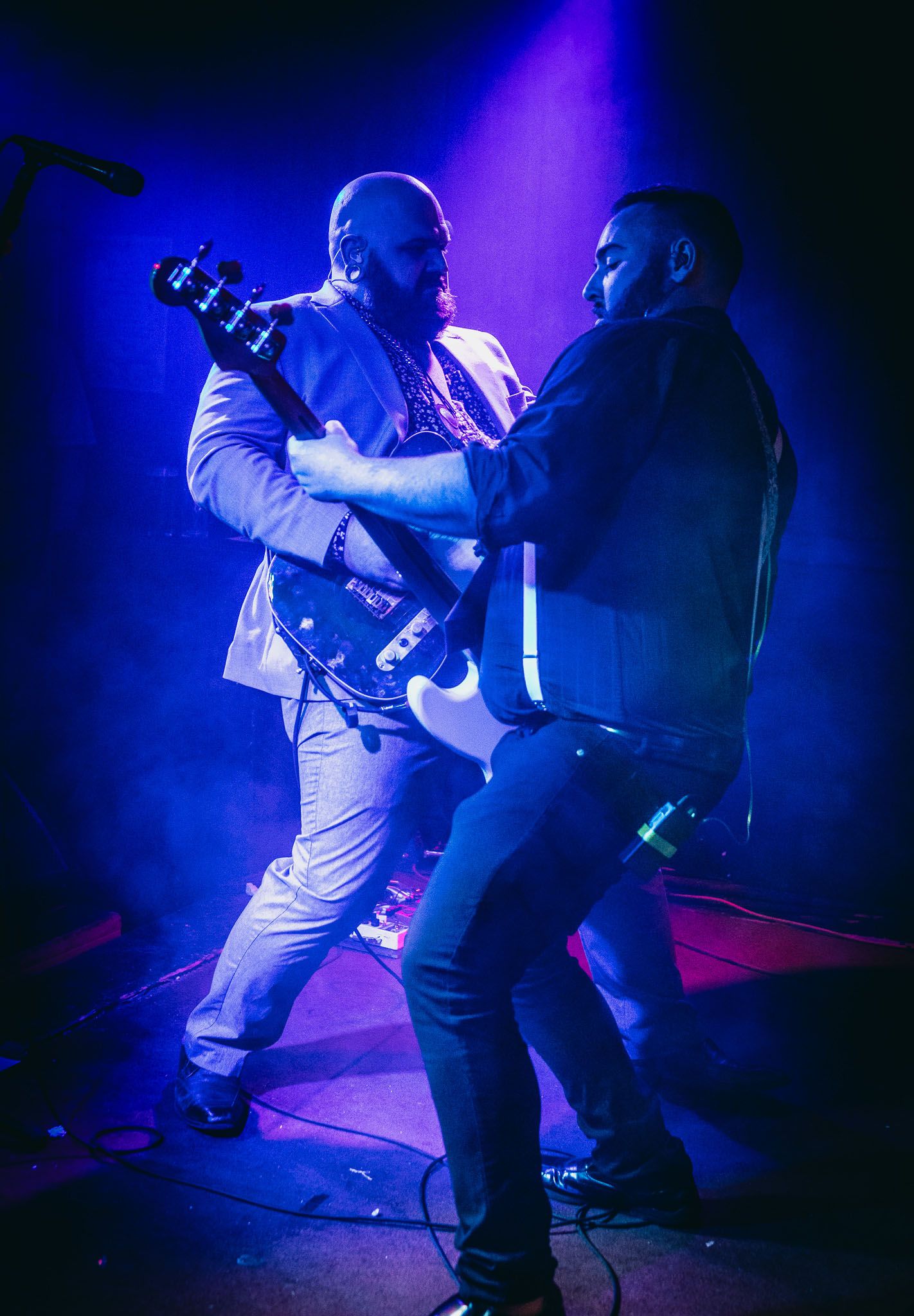 Two guitar players playing on stage